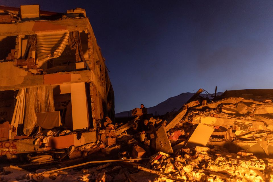 People gather boxes on the remains of a destroyed building in the aftermath of a deadly earthquake in Elbistan, Turkey February 14, 2023. Photo: Reuters