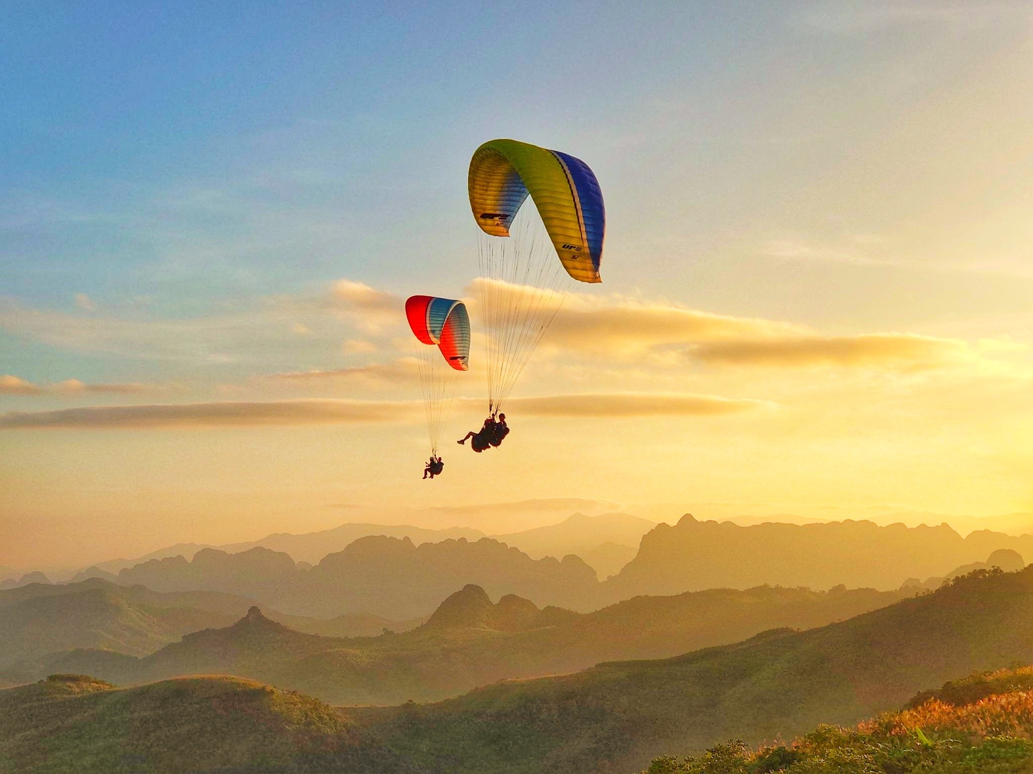 Paragliders fly under the sunset at Bu Hill on the outskirts of Hanoi, Vietnam. Photo by courtesy of Mebayluon