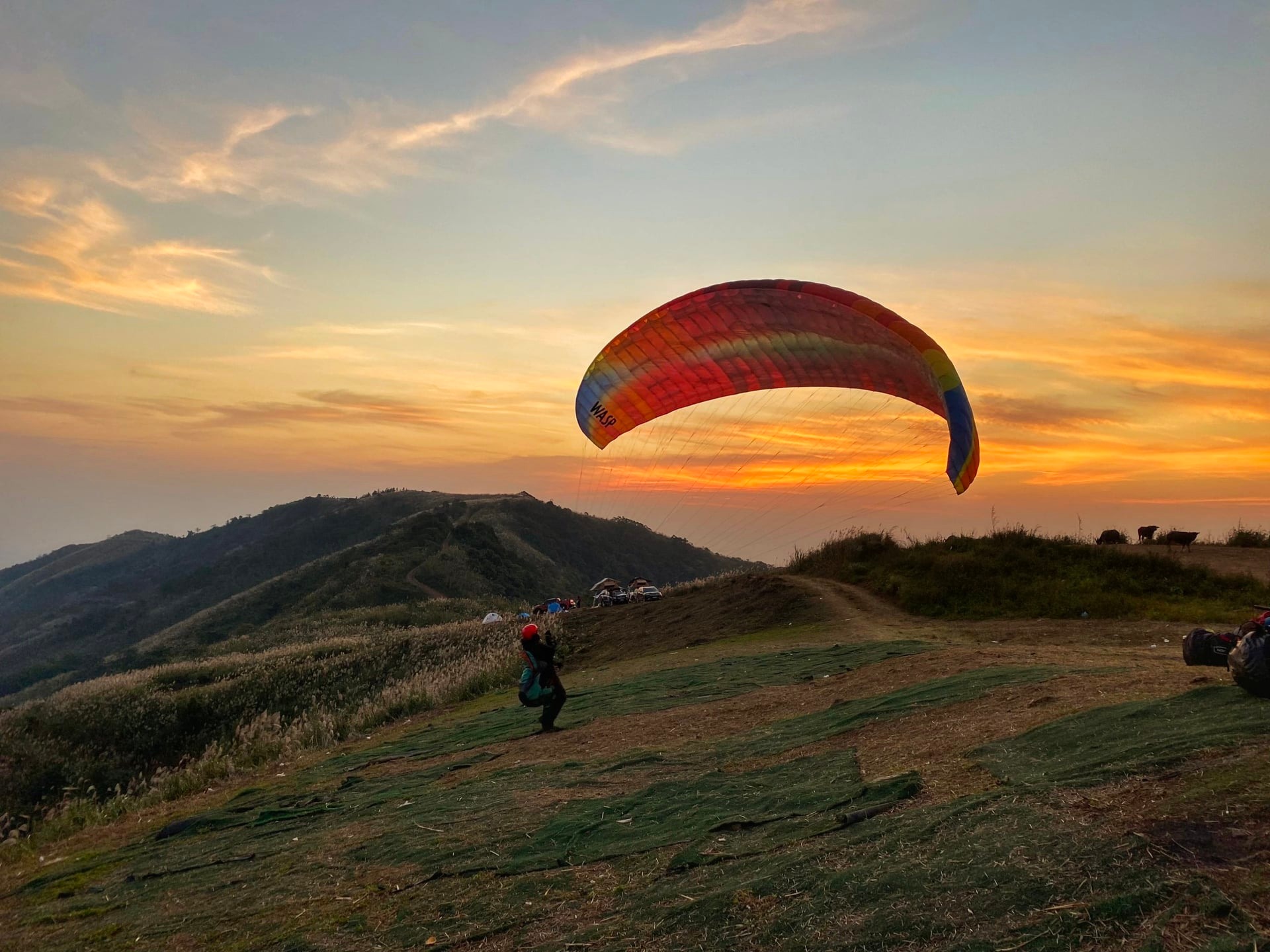 A paraglider flies under the sunset at Bu Hill on the outskirts of Hanoi, Vietnam. Photo by courtesy of Mebayluon
