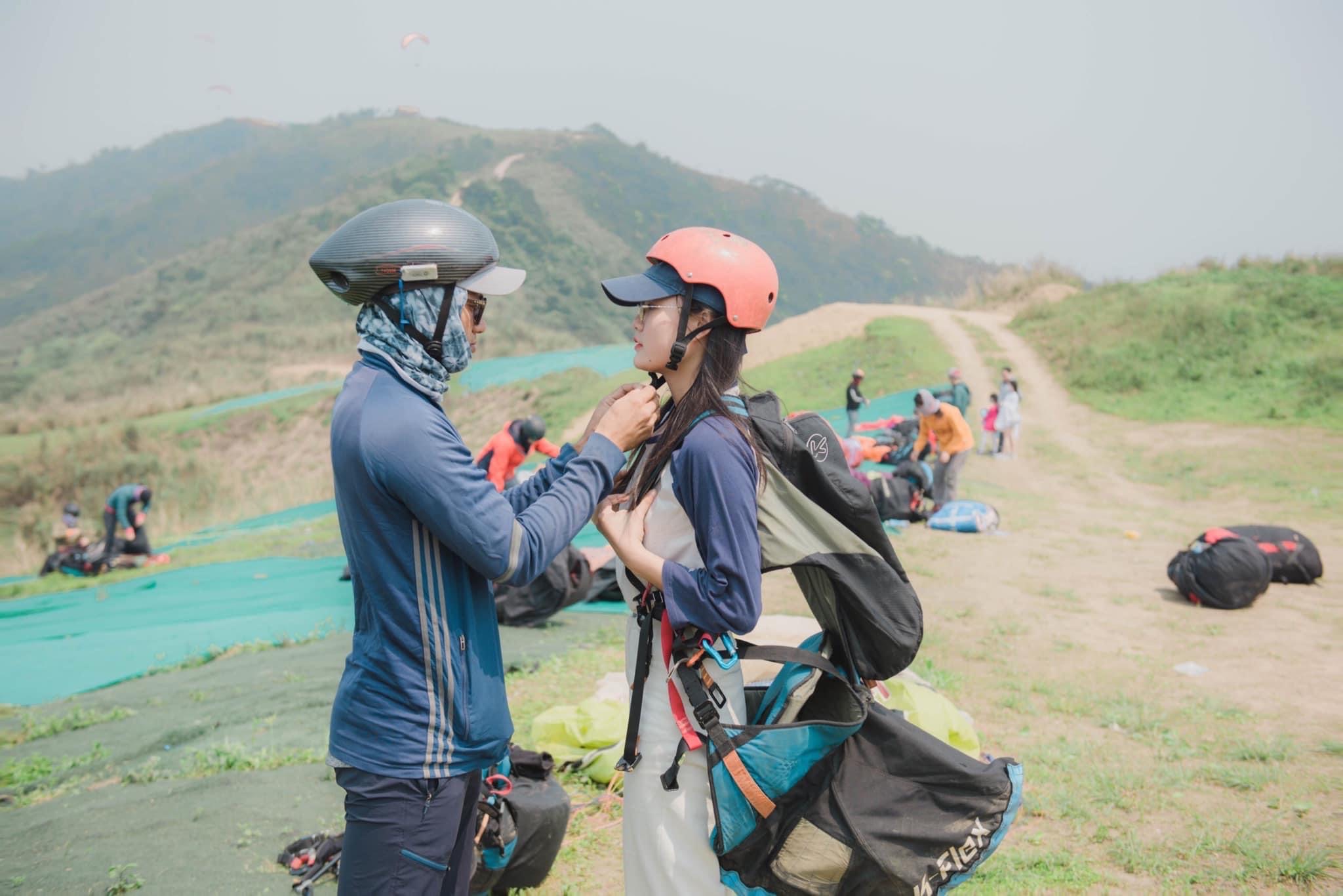 A professional equips safety gadgets for a tourist before taking off for paragliding at Bu Hill on the outskirts of Hanoi, Vietnam. Photo by courtesy of Mebayluon