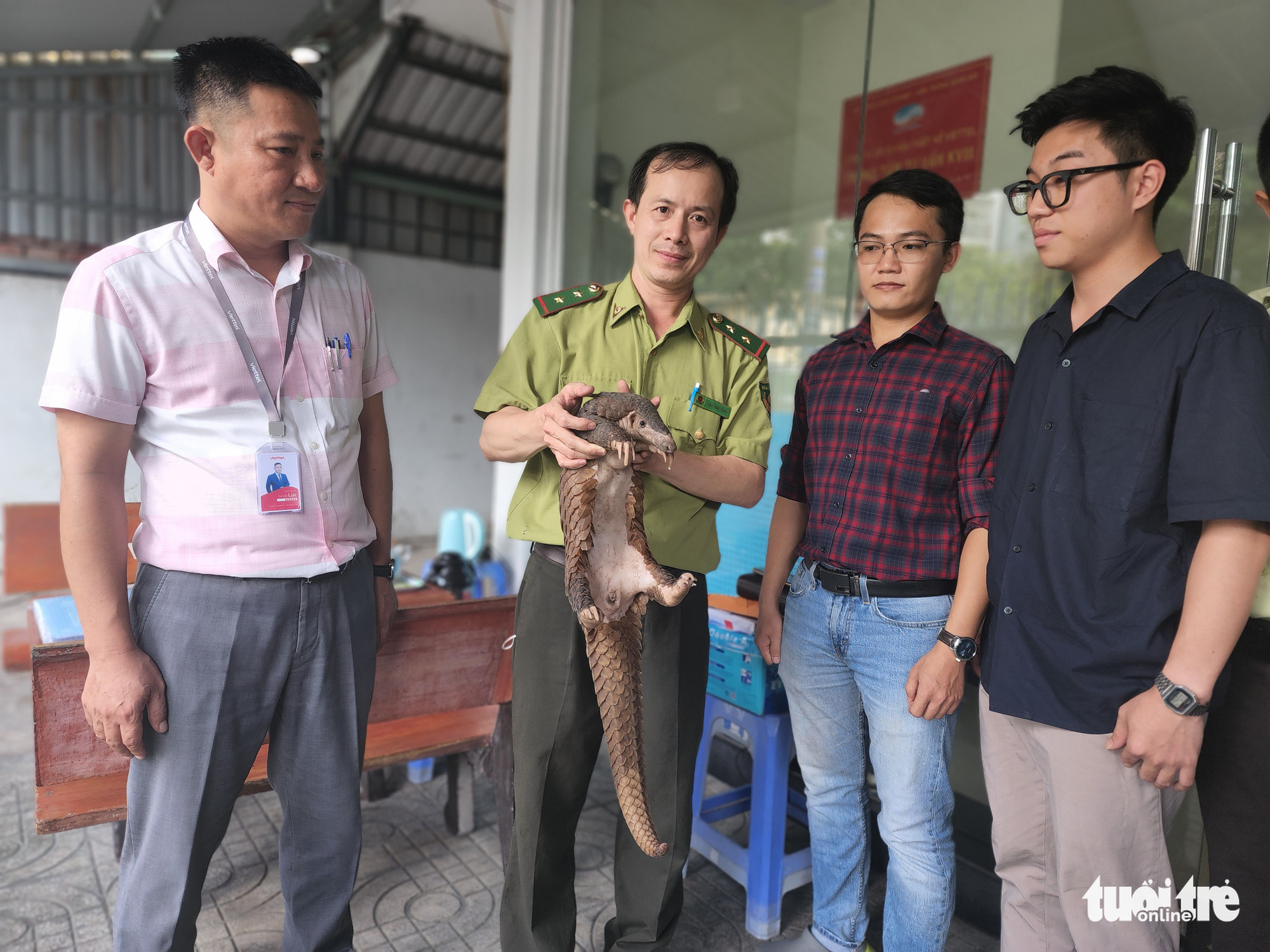 A ranger receives a four-kilogram Javan pangolin from two men in District 12, Ho Chi Minh City, October 26, 2022. Photo: Ngoc Khai / Tuoi Tre
