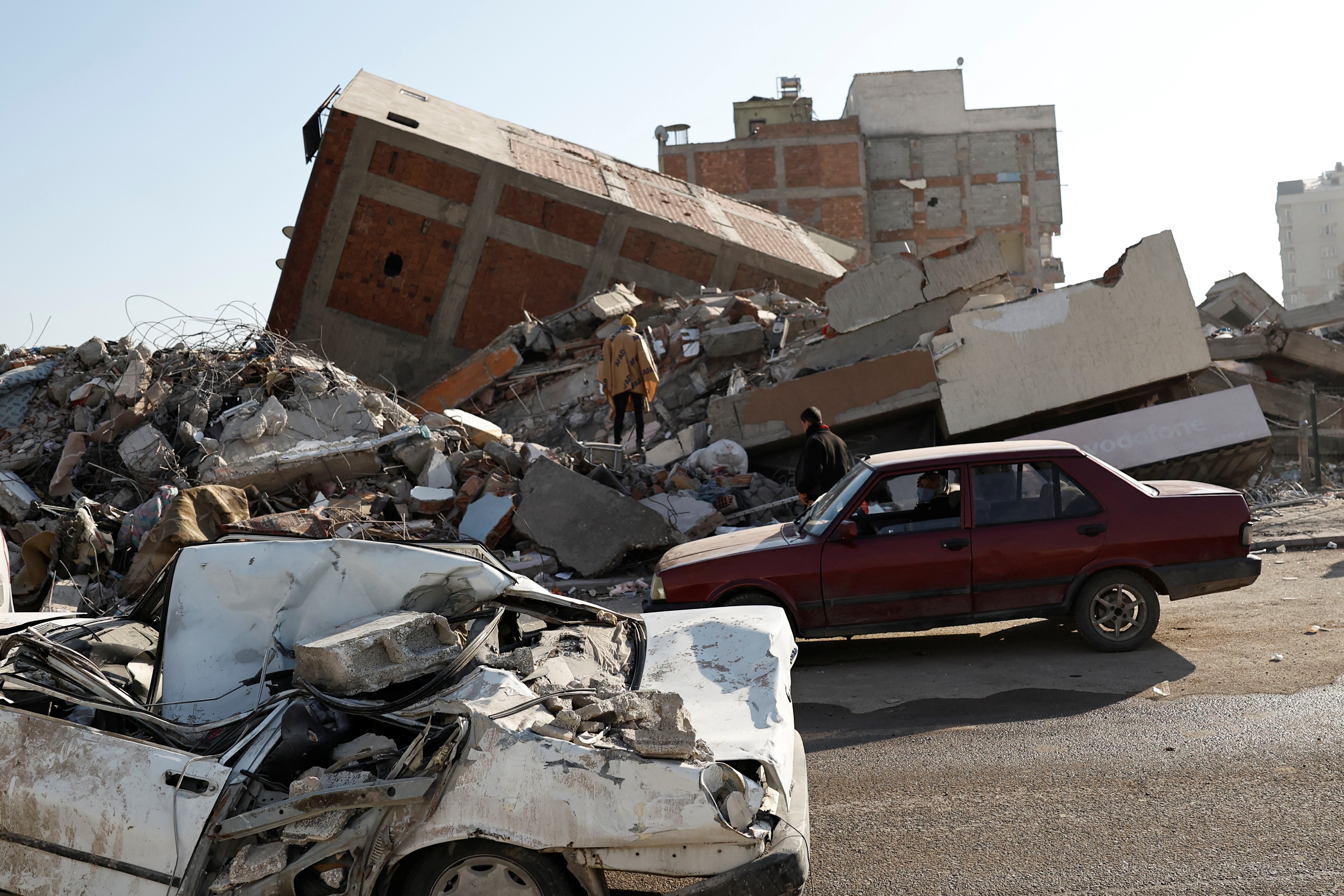 A family parks their car in front of their former home and collects personal belongings they retrieved from the rubble, in the aftermath of a deadly earthquake, in Kahramanmaras, Turkey, February 18 2023. Photo: Reuters
