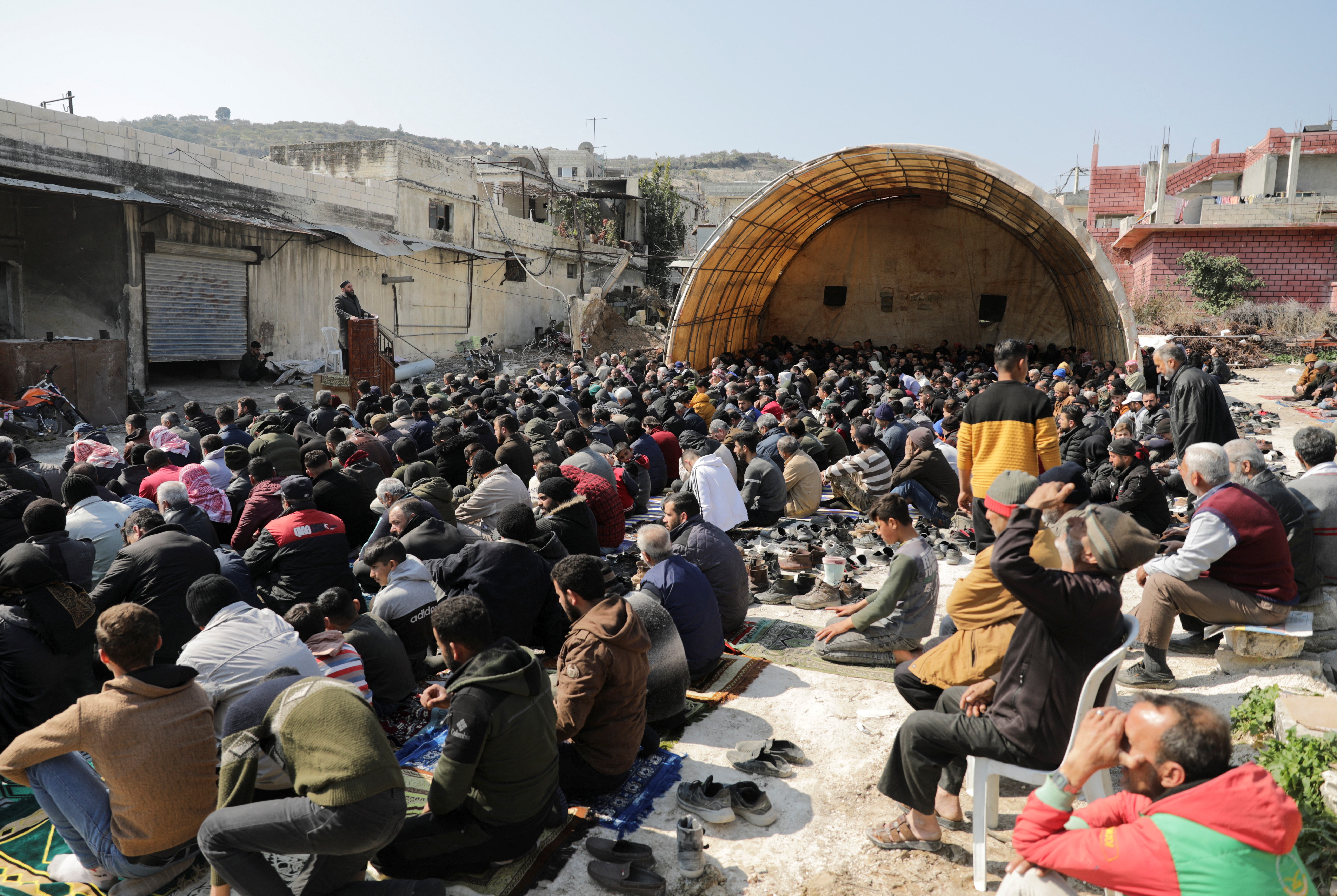 People pray outdoor during Friday prayers, after their village's mosque was destroyed in the aftermath of a deadly earthquake, in rebel-held al-Maland village, in Idlib province, Syria February 24, 2023. Photo: Reuters