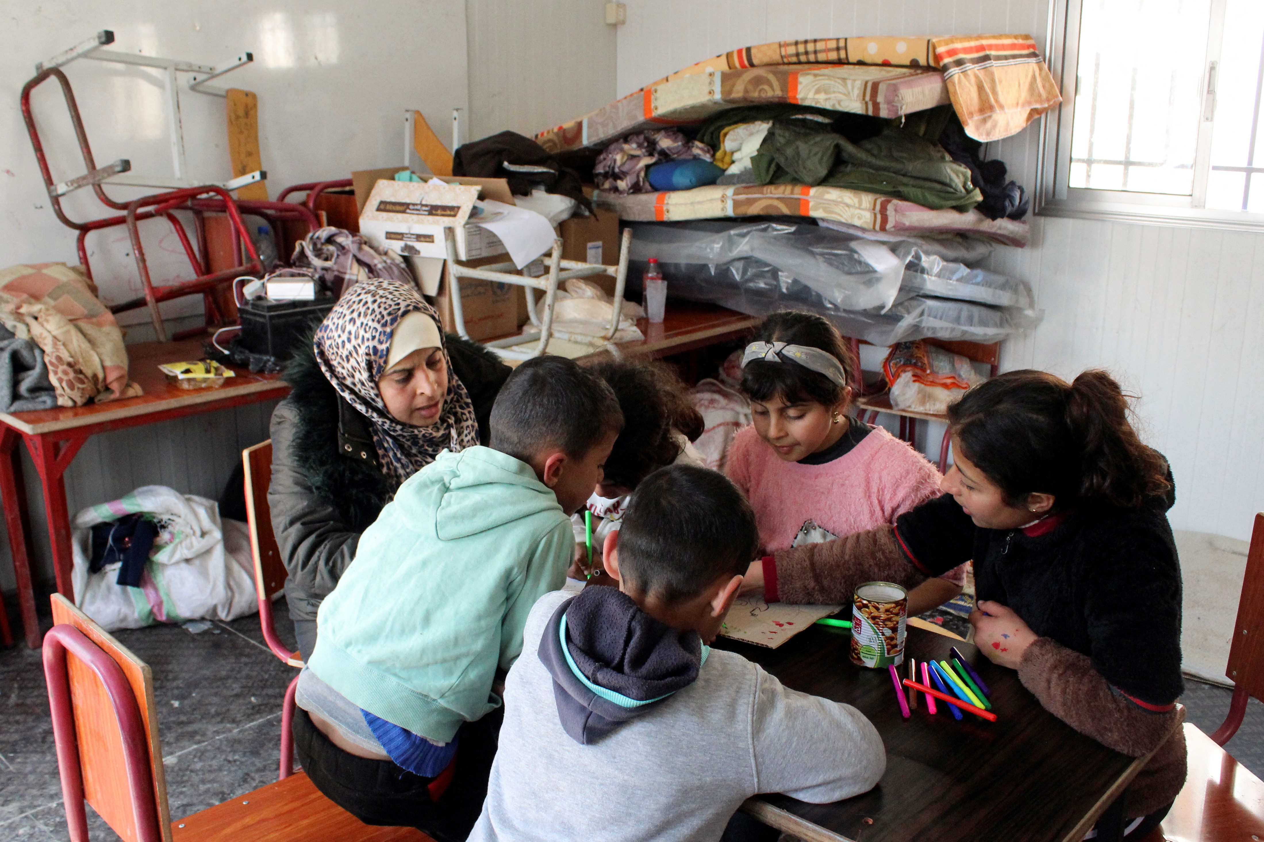Yasmine Asaad Yassin, a 39-year-old mother of three, sits with her children and others in a school turned to a shelter for families affected by the deadly earthquake, in Latakia, Syria, February 23, 2023. Photo: Reuters