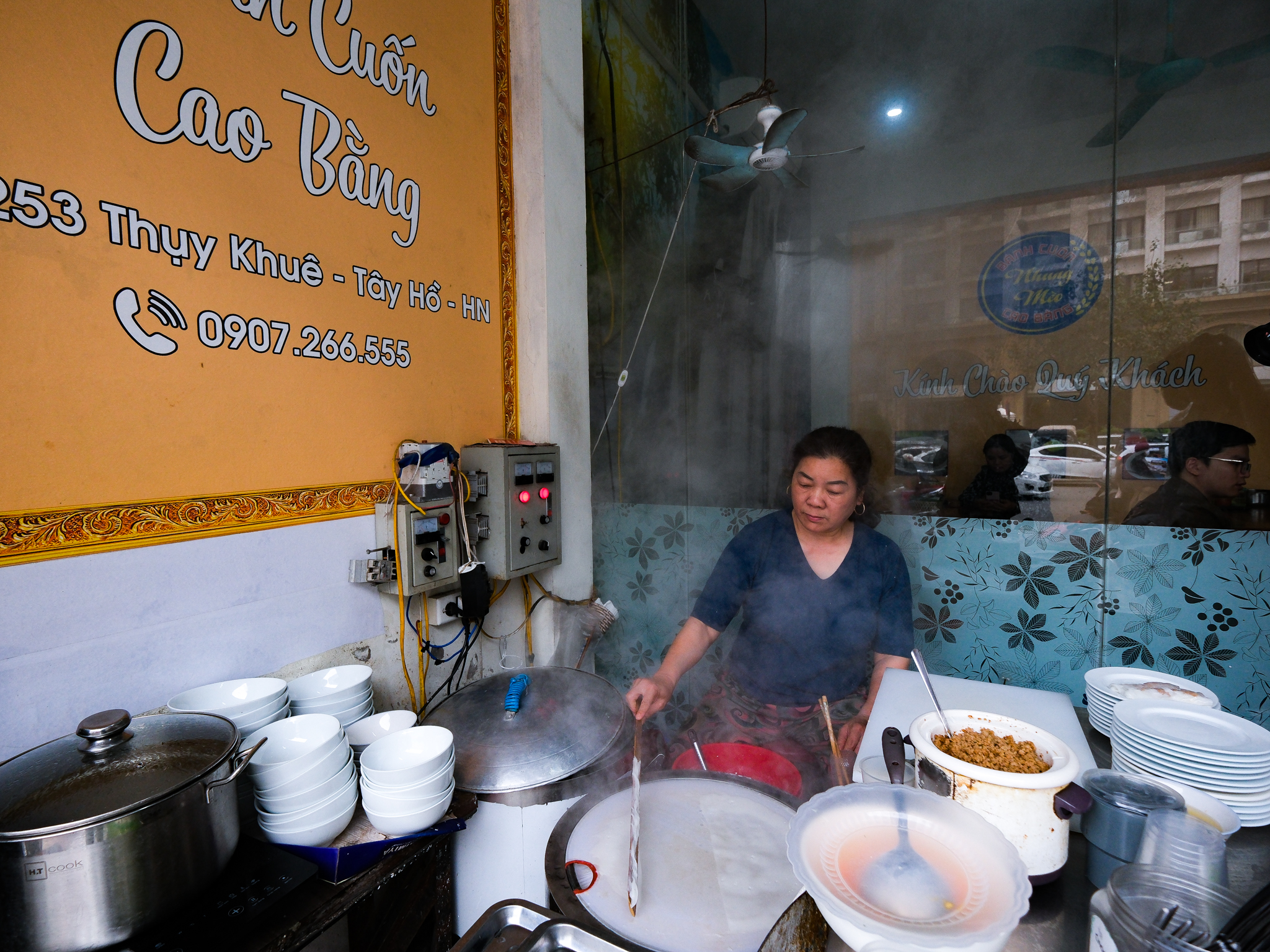 Dinh Thi Tam makes banh cuon (steamed rice rolls) at her Banh Cuon Cao Bang stall in Hanoi, Vietnam. Photo: Nam Tran / Tuoi Tre News