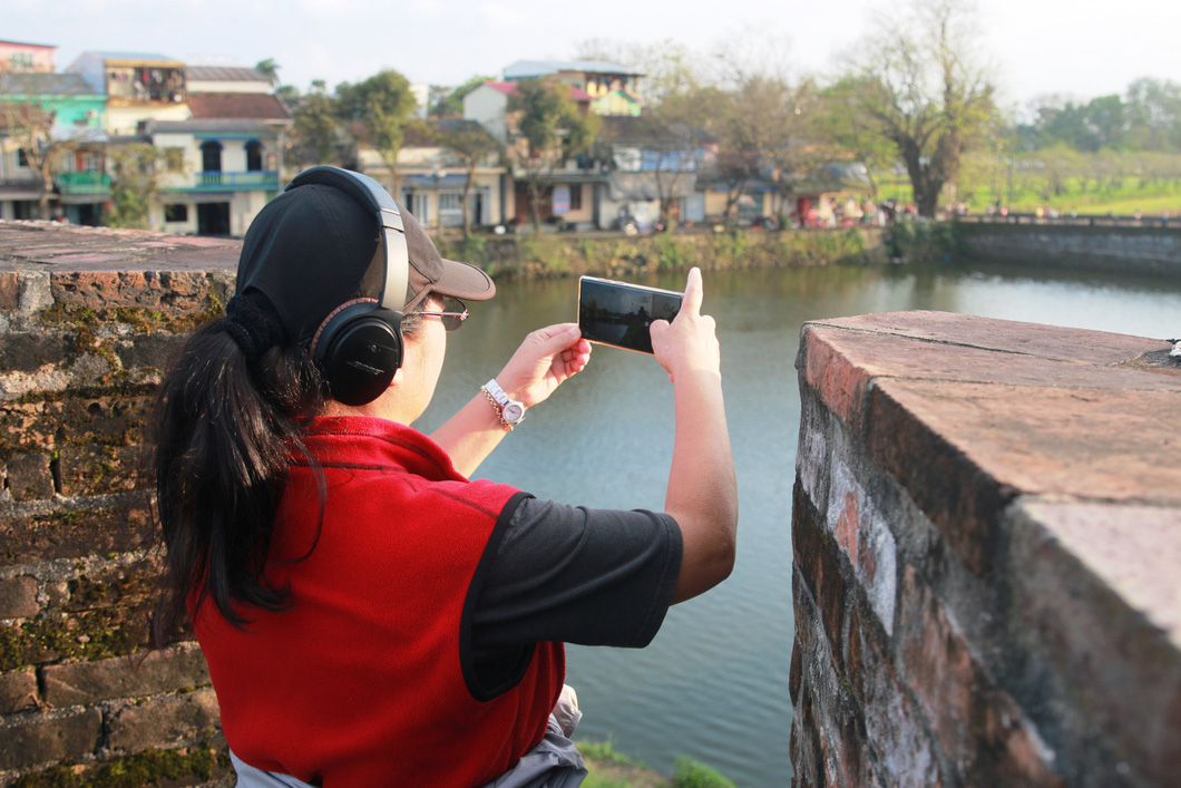 A tourist takes a photo at a cannon embrasure. Photo: Nhat Linh / Tuoi Tre