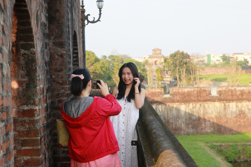 Visitors takes a photo while visiting the watchtower at Ngan Gate. Photo: Nhat Linh / Tuoi Tre