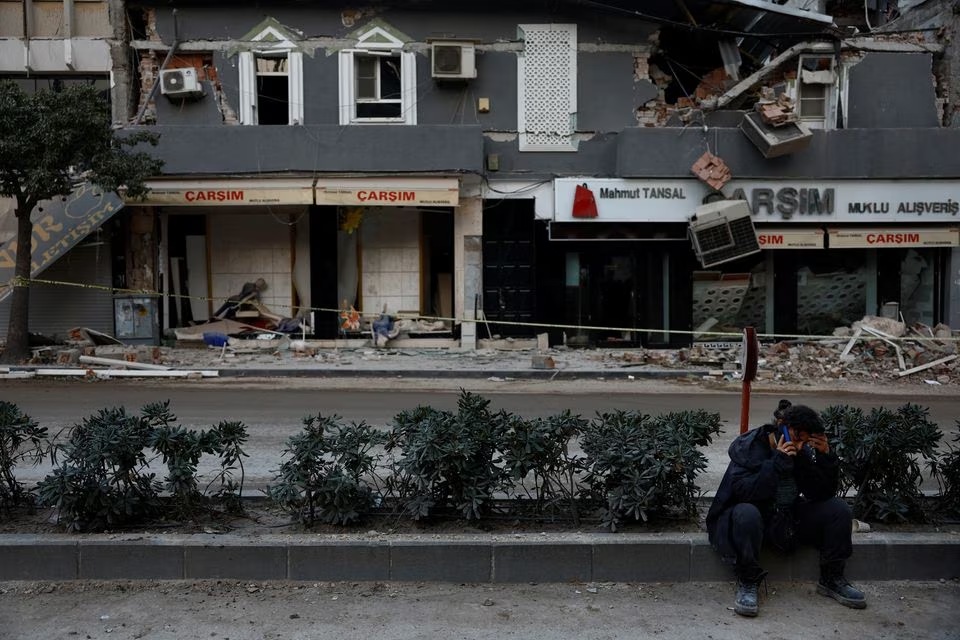Hatice Yigit, 57, speaks on the phone as she waits for news on the search for the gold and money she saved for her daughter's engagement in the remains of her collapsed home after a deadly earthquake in Antakya, Hatay province, Turkey, March 1, 2023. Photo: Reuters