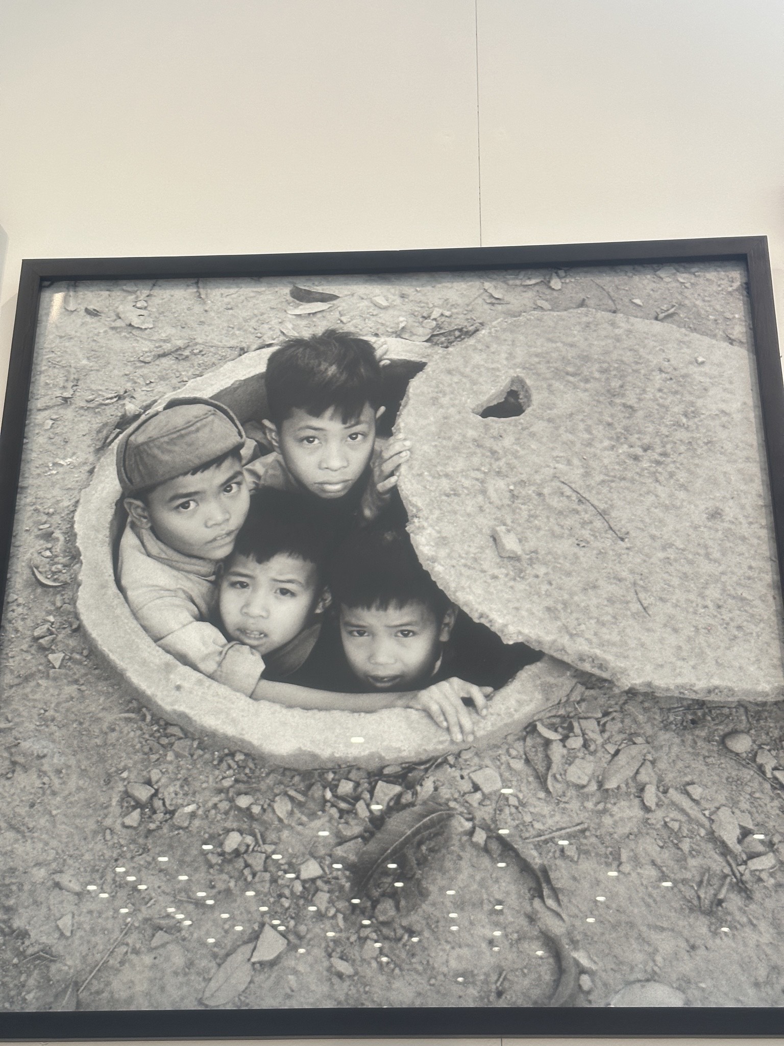 A photo shows children hiding in a concrete shelter tube in Hanoi in 1968 at the exhibition. Photo: Tieu Bac / Tuoi Tre News
