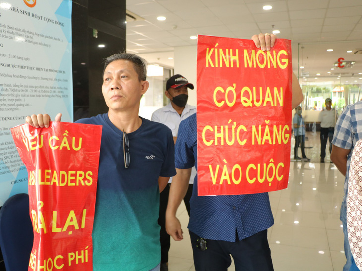 Parents hold banners asking APAX Leaders to refund the tuition fees and calling on the involvement of state agencies. Photo: Trong Nhan / Tuoi Tre