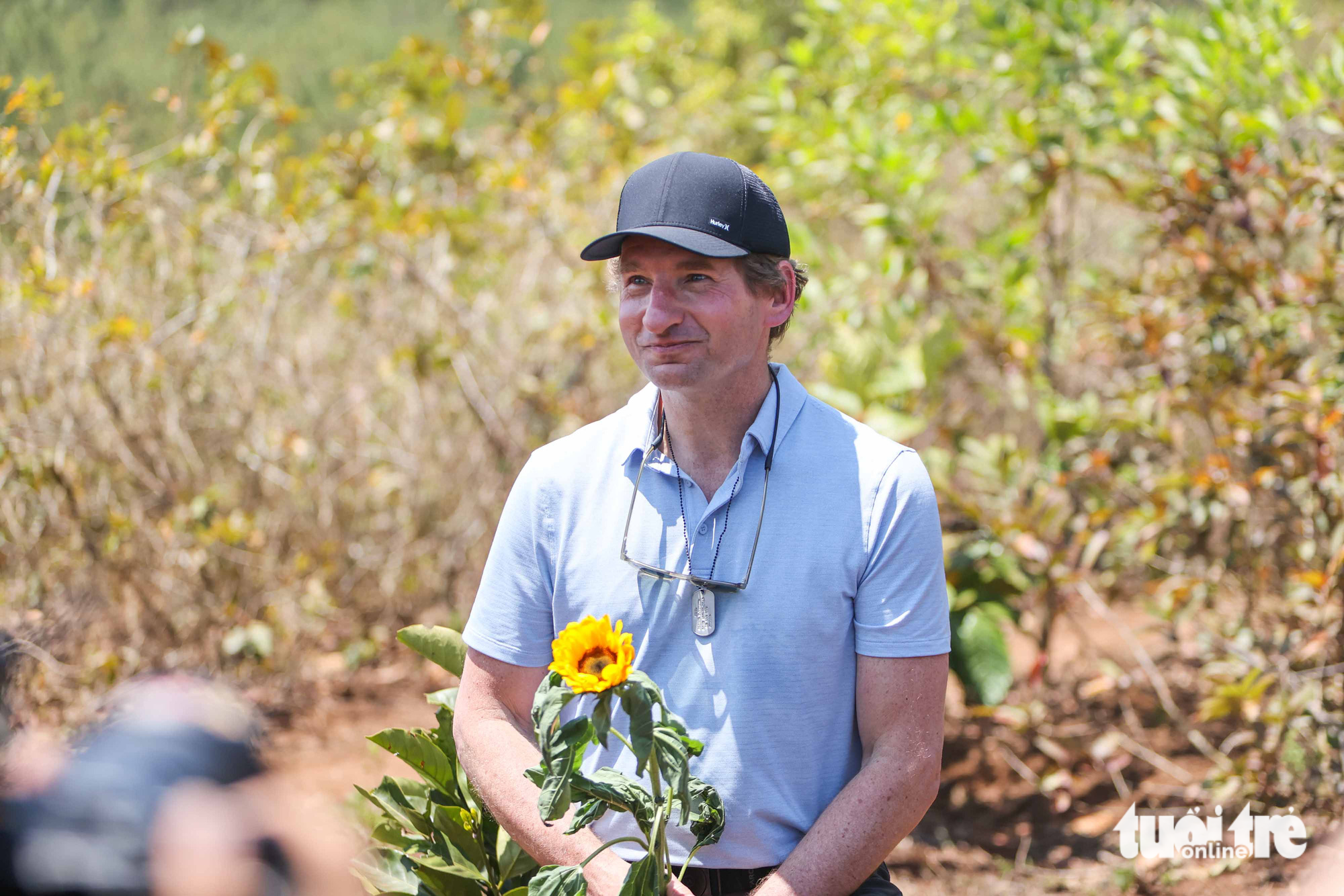 Dean Phillips holds a sunflower branch to commemorate his father. “I think the two countries will show the whole world the meaning of reconciliation, making friends, and protecting lives, not taking lives, the respect for different political systems, and the respect for each other.” Photo: Nguyen Khanh / Tuoi Tre