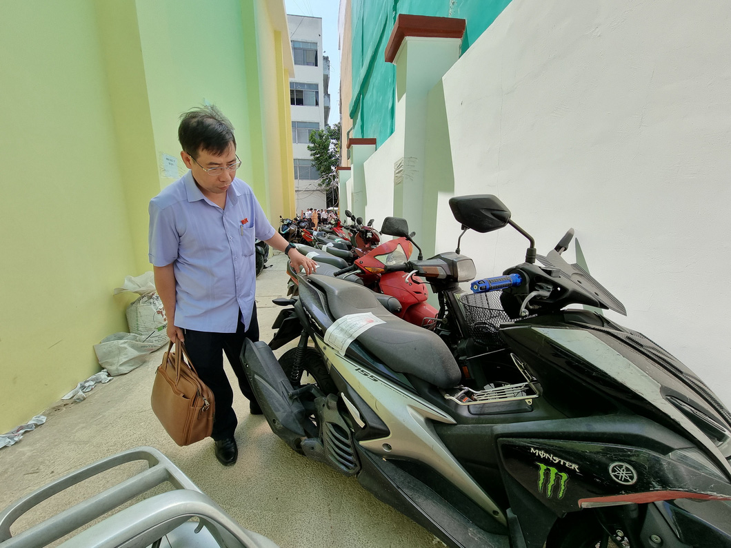 Deputy head of the Ho Chi Minh City People’s Council’s legislation board Le Minh Duc inspects motorbikes of residents violating alcohol concentration regulations left at the headquarters of the District 1 Police at 73 Yersin Street in District 1, Ho Chi Minh City. Photo: Ai Nhan / Tuoi Tre