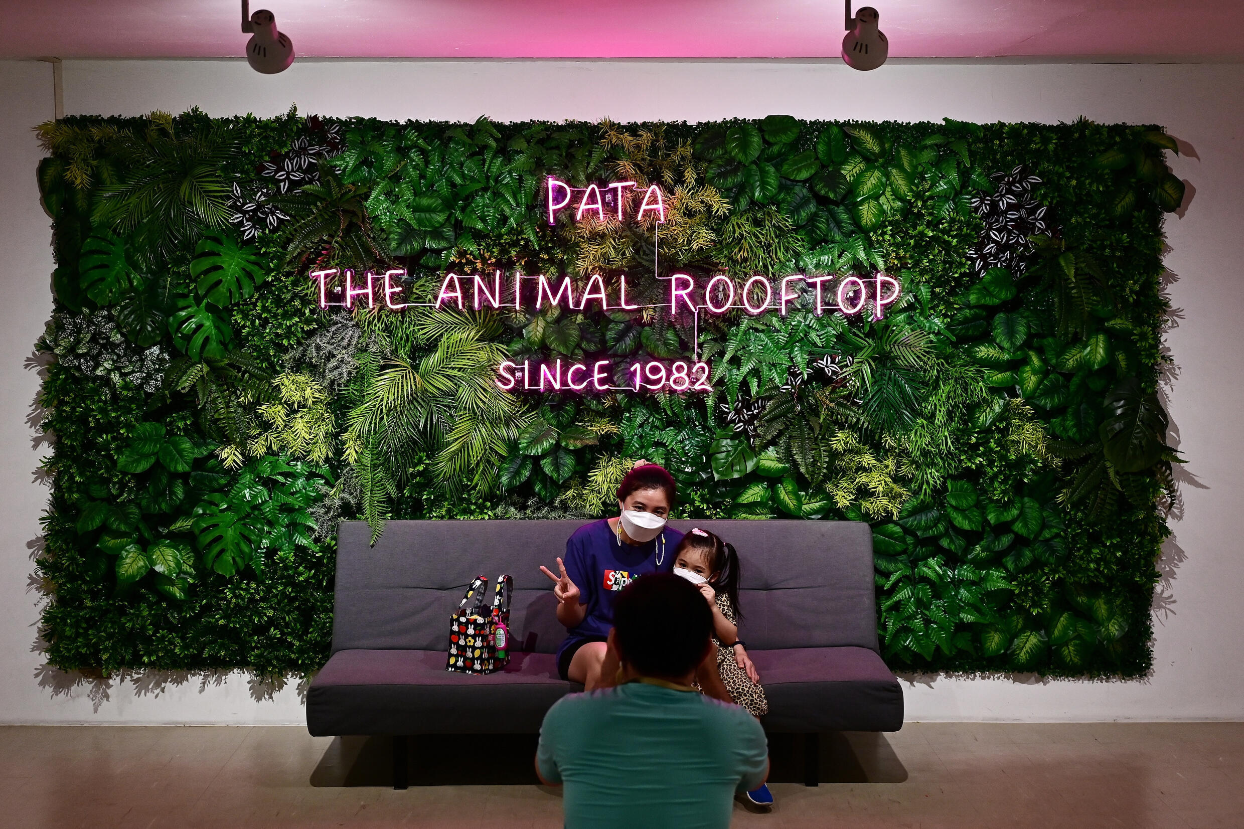 In this photograph taken on March 19, 2023 visitors pose for photo at the entrance of Pata Zoo in Bangkok. Photo: AFP