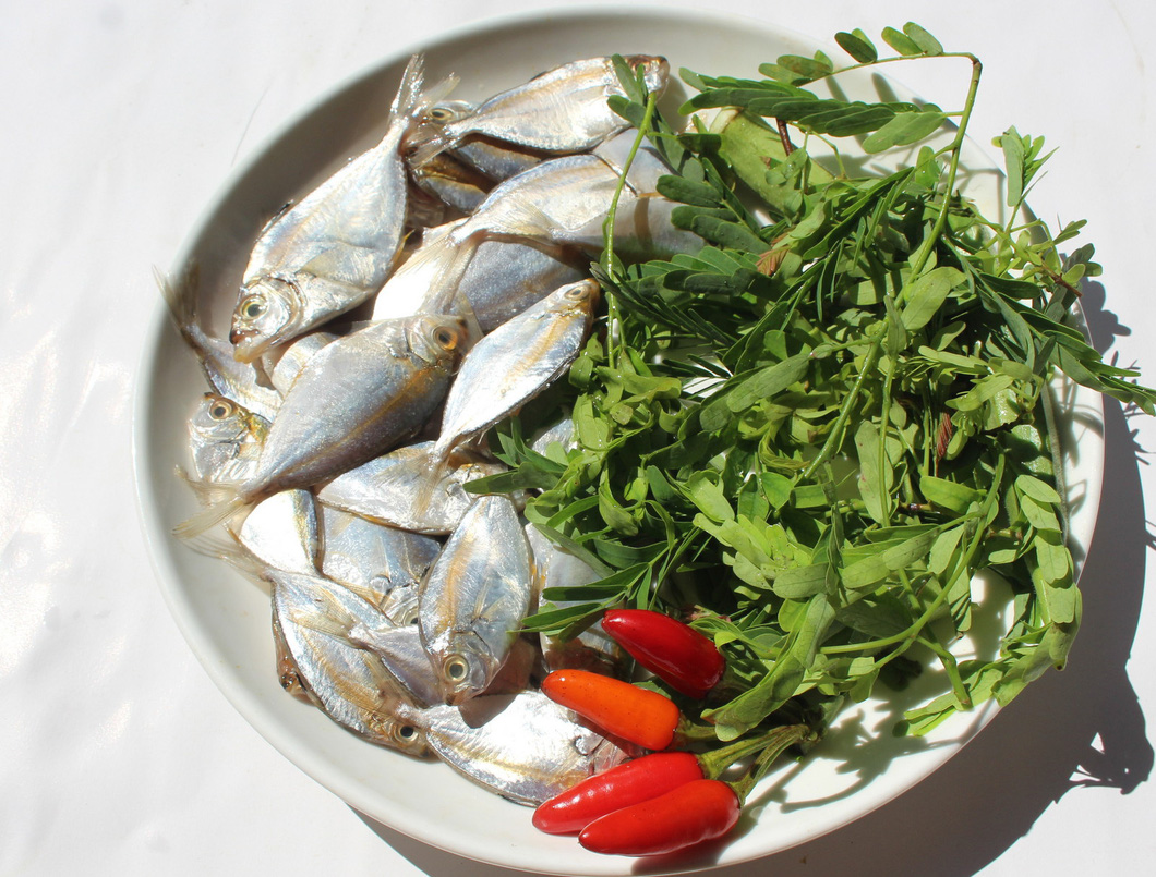 A plate features fresh ponyfish, tamarind leaves and chili. Photo: Hoa Vang / Tuoi Tre