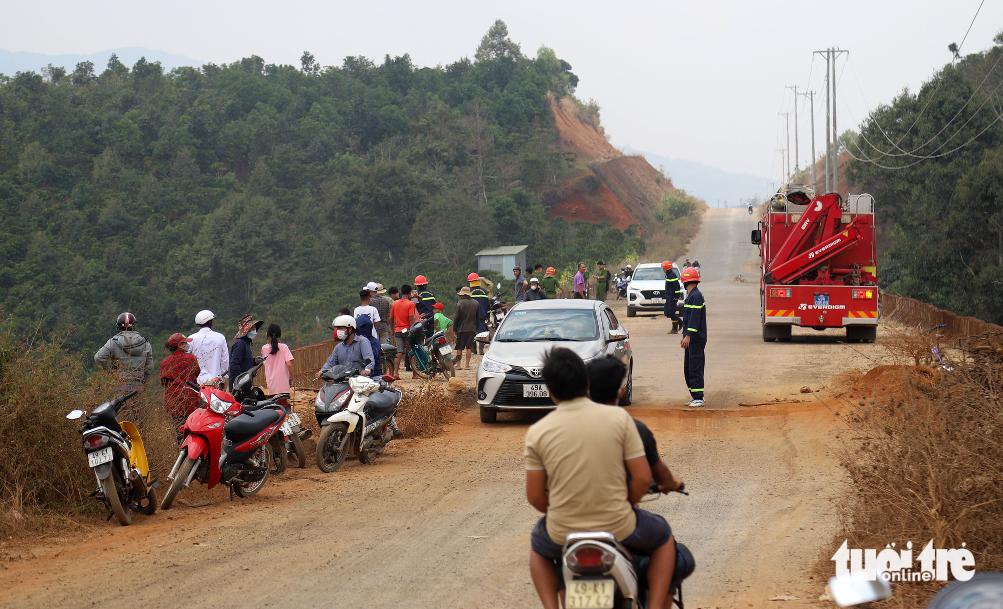 Officers and onlookers gather at the scene after a Ford Everest crashed into an abyss below the Nau Sri Bridge in Bao Loc City, Lam Dong Province, Vietnam, March 23, 2023. Photo: M.V. / Tuoi Tre