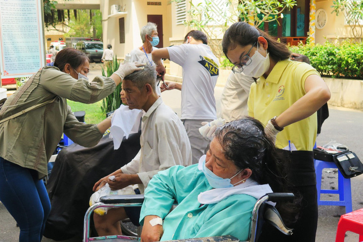 Part of the hospital yard is used as a salon for free haircut and washing services. Photo: Hoai Bao / Tuoi Tre