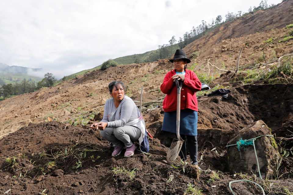 People rest as they dig amid debris as they look for relatives, following a landslide, in Alausi, Ecuador March 28, 2023. Photo: Reuters