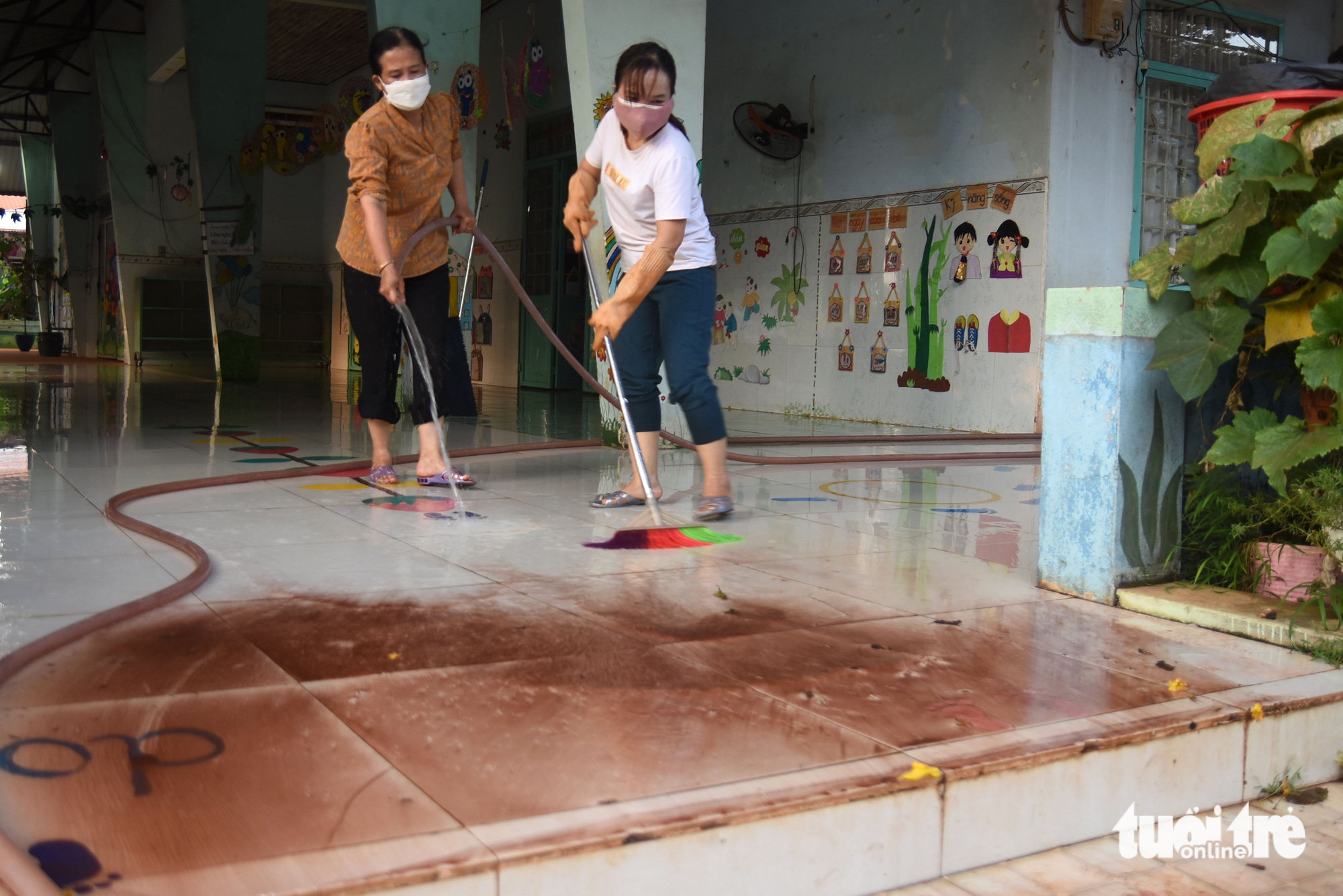 Teachers mop the floor of Binh Son Kindergarten, which was cloaked in dust from the construction site of the Long Thanh International Airport project in Dong Nai Province, southern Vietnam, March 28, 2023. Photo: A Loc / Tuoi Tre