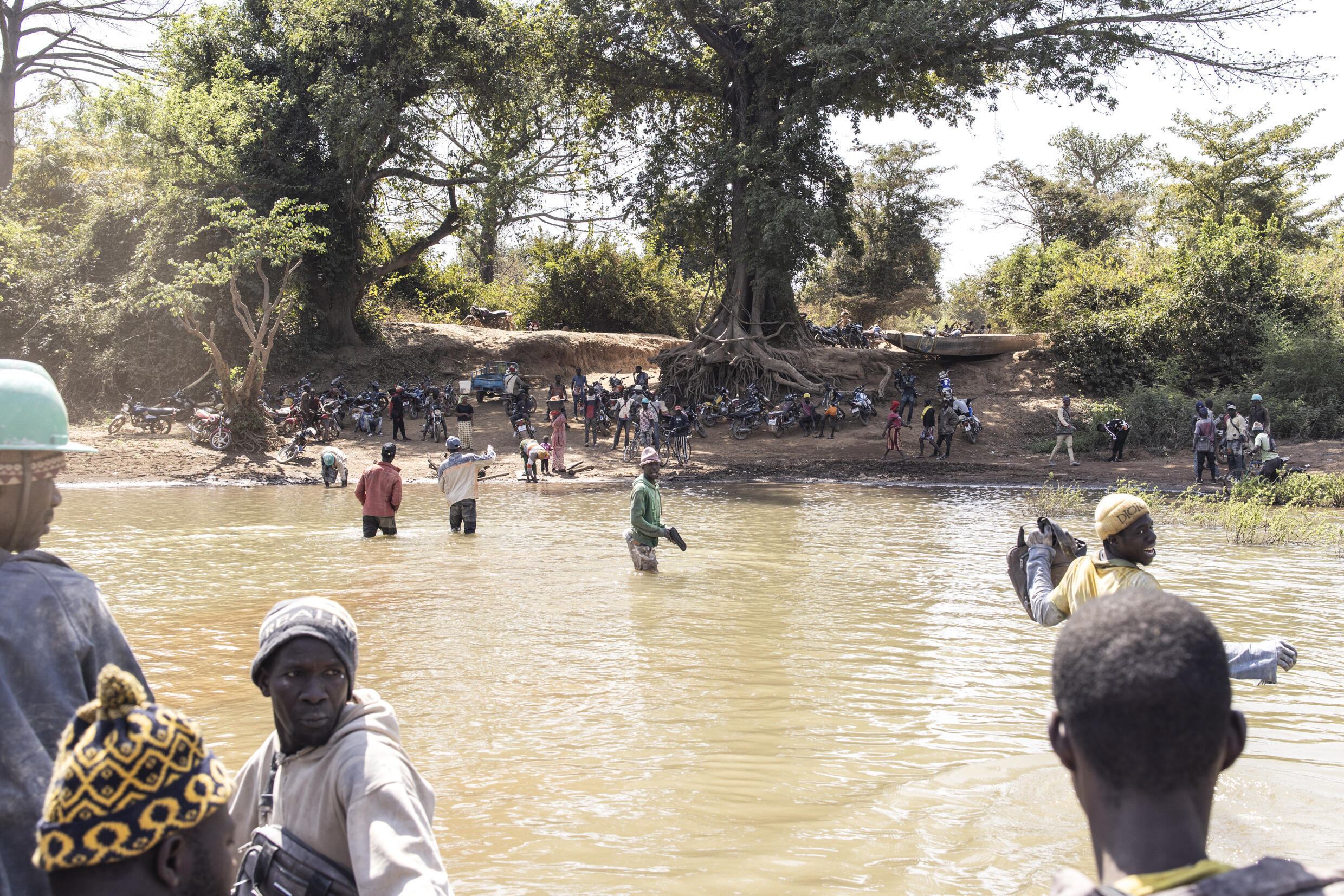 Artisanal gold miners cross The Gambia river at the Bantakokouta gold mine on February 2, 2023. Photo: AFP