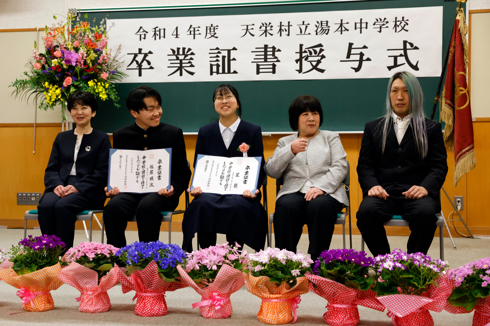 Eita and Aoi attend a photo session with Eita’s mother Masumi and Aoi’s grandmother Hisako (second from the right), 68, and father Kazuhisa, 37, after the students’ graduation and the institution’s closing ceremony, in Ten-ei Village, Japan March 13, 2023. Photo: Reuters