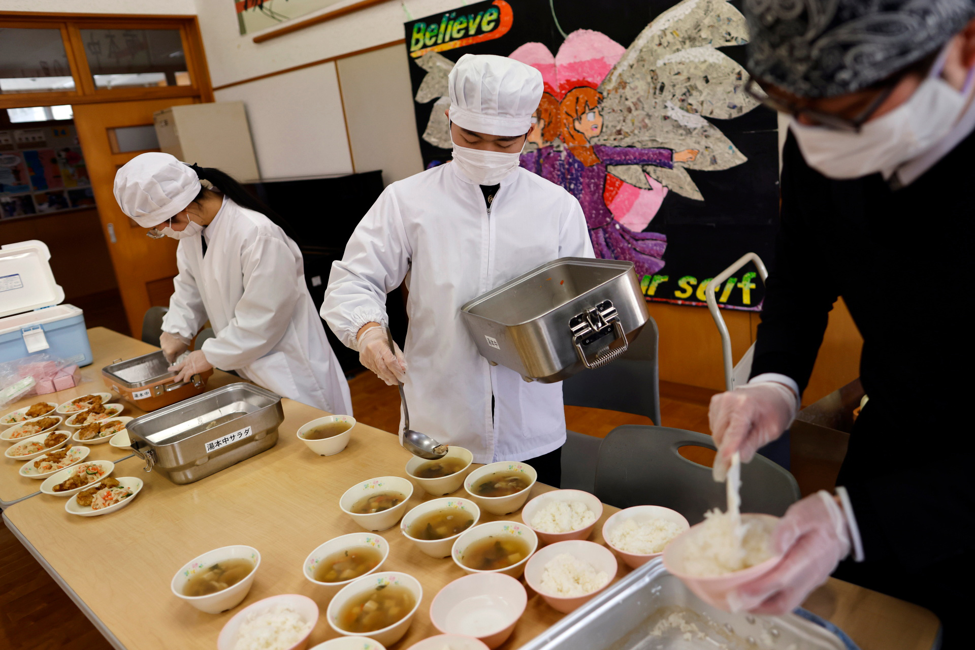 Eita and Aoi, serve their last school lunch for themselves and their teachers a few days before graduation and the school’s closing ceremony in Ten-ei Village, Japan, March 9, 2023. Photo: Reuters