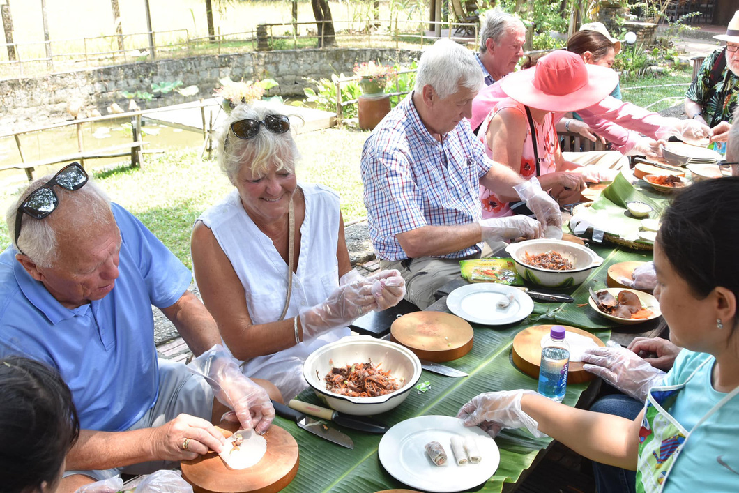 International cruise visitors learn how to make cha ram, a local spring roll Khanh Hoa Province, central Vietnam. Photo: Thuc Nghi / Tuoi Tre