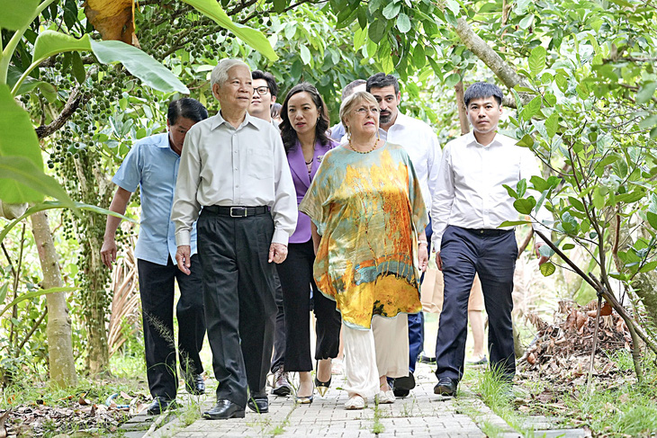 Former Vietnamese State President Nguyen Minh Triet introduces his garden in Binh Duong Province to Michelle Bachelet on March 30, 2023. Photo: Huu Hanh / Tuoi Tre