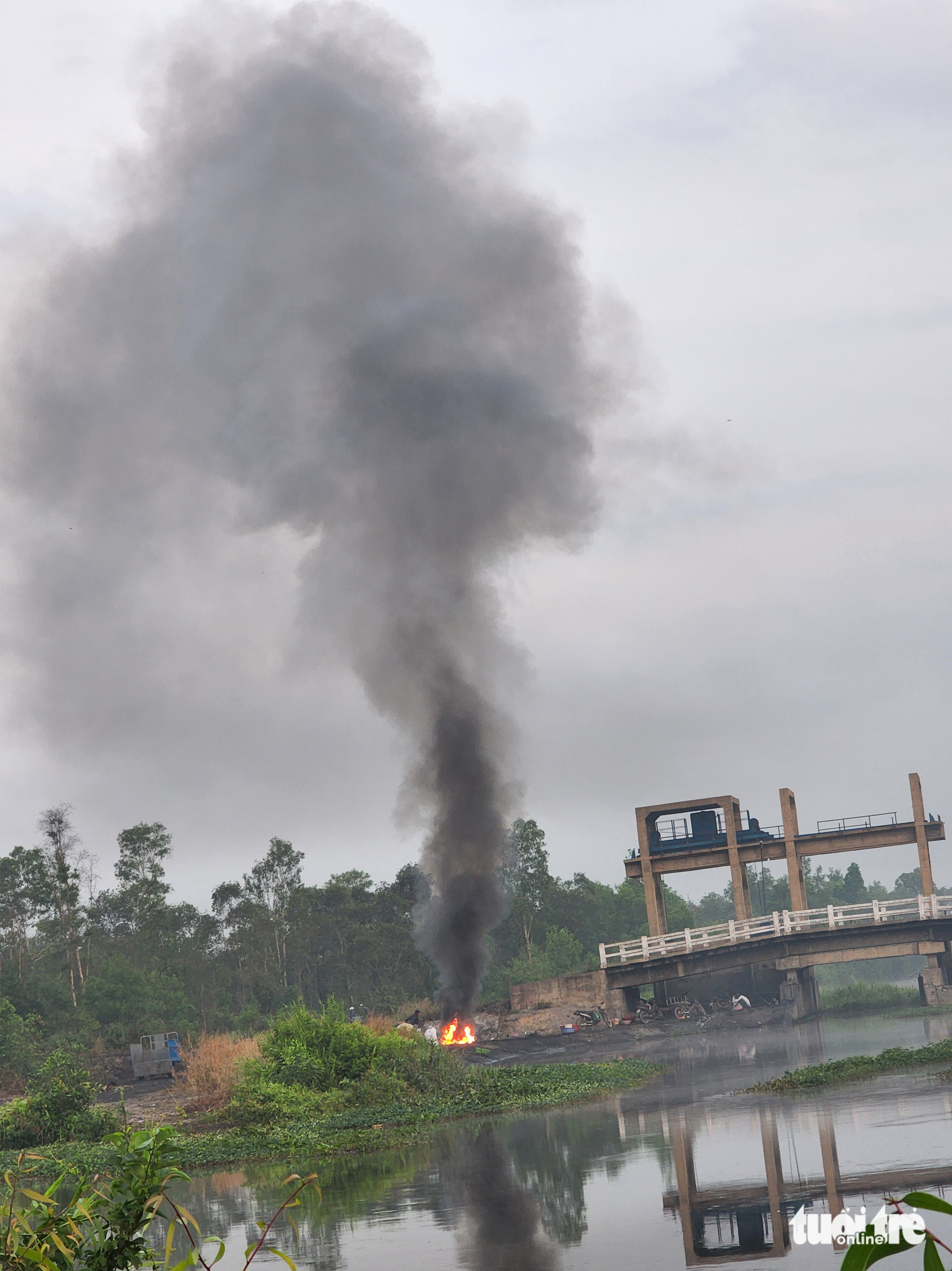 People burn scrap near Hai Phung Bridge on the morning of March 16, 2023. Photo: Tuoi Tre