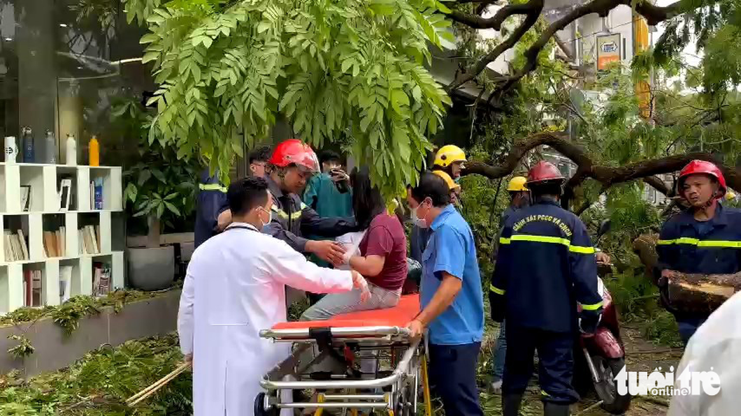 A photo shows an injured woman being put on a stretch at the scene of an uprooted tree at Tran Van On Middle School on April 3, 2023. Photo: C.T. / Tuoi Tre