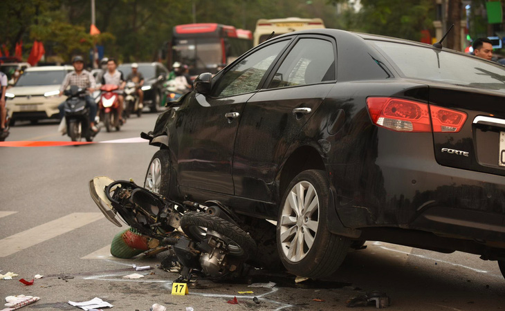 A photo shows a car crushing a motorcycle. Photo: Danh Trong / Tuoi Tre