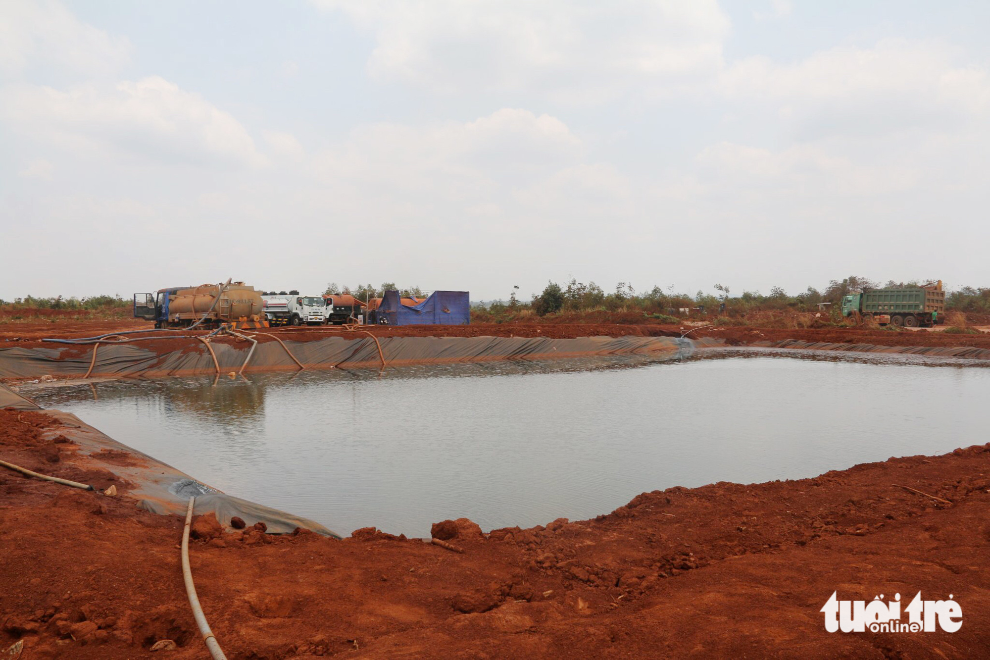 A reservoir supplies water for tank trucks to spray water at the site.