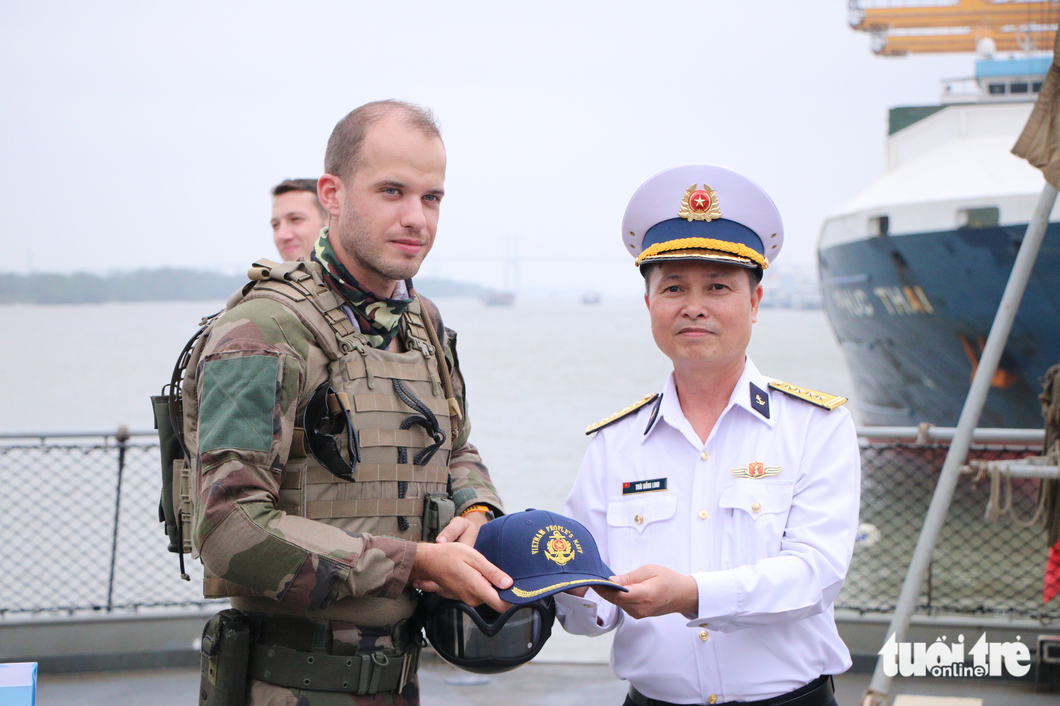 A representative of the frigate Prairial crew receives a souvenir from the Vietnam People's Navy. Photo: Duy Linh / Tuoi Tre