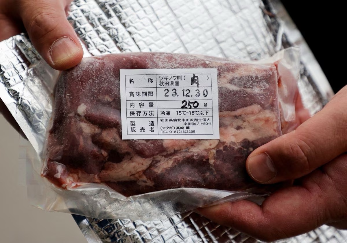 Daishi Sato, owner of a soba noodle restaurant and the vending machine, shows a pack of Asian Black Bear meat next to the vending machine, in front of his restaurant in Semboku, Akita prefecture, Japan, April 6, 2023. Photo: Reuters