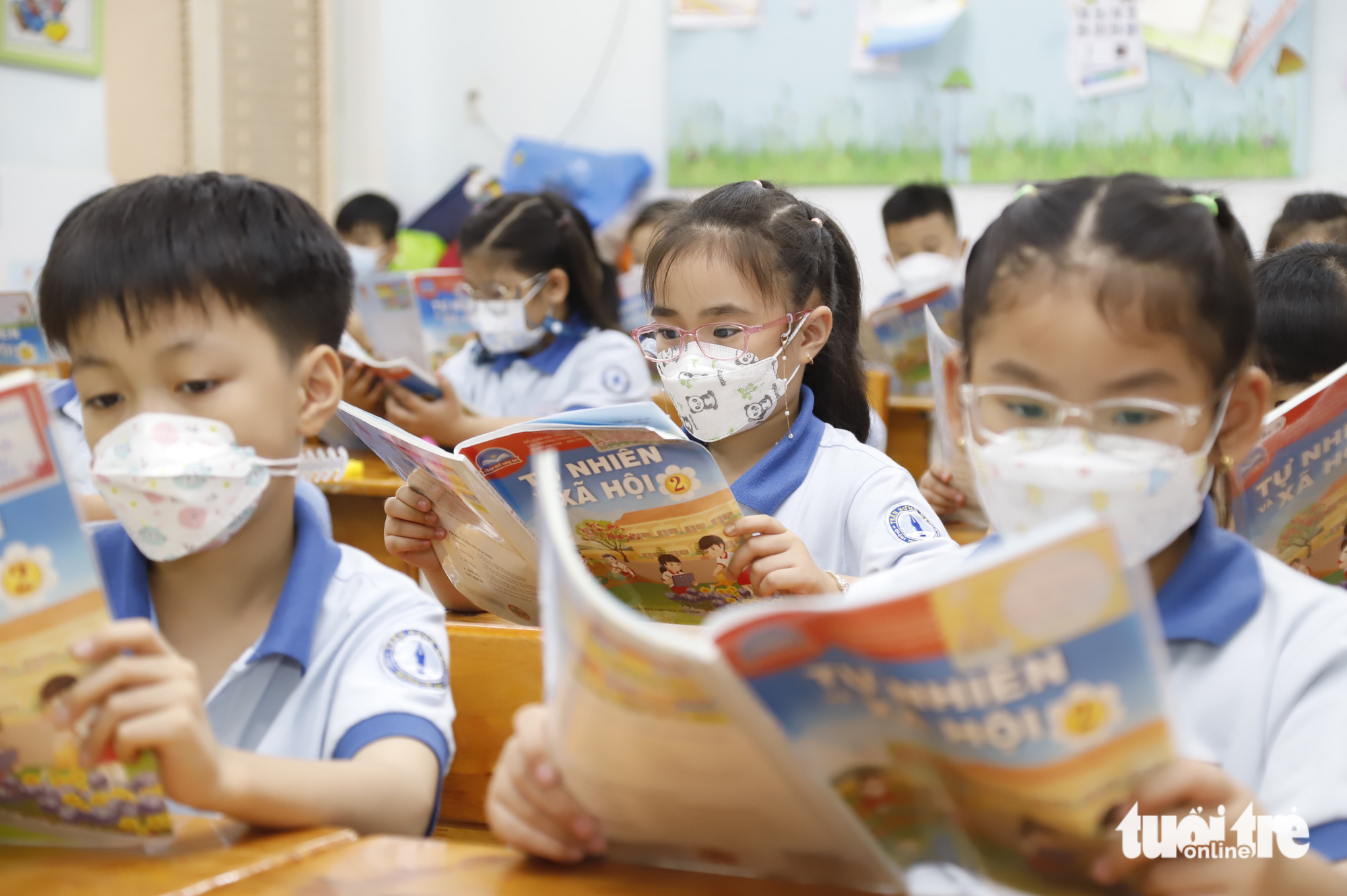 Children wearing glasses read textbooks at school in Vietnam. Photo: Nhu Hung / Tuoi Tre