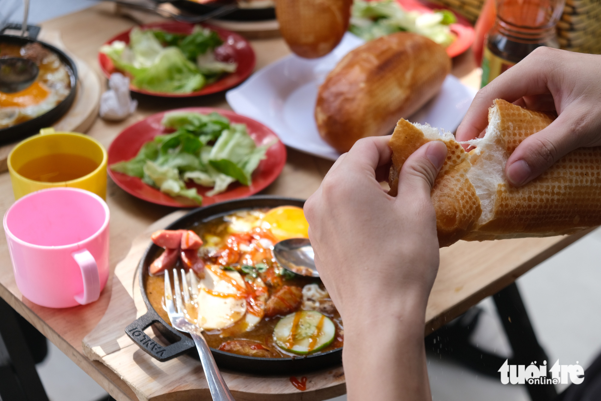 A diner savors banh mi chao. Photo: Ngoc Phuong / Tuoi Tre