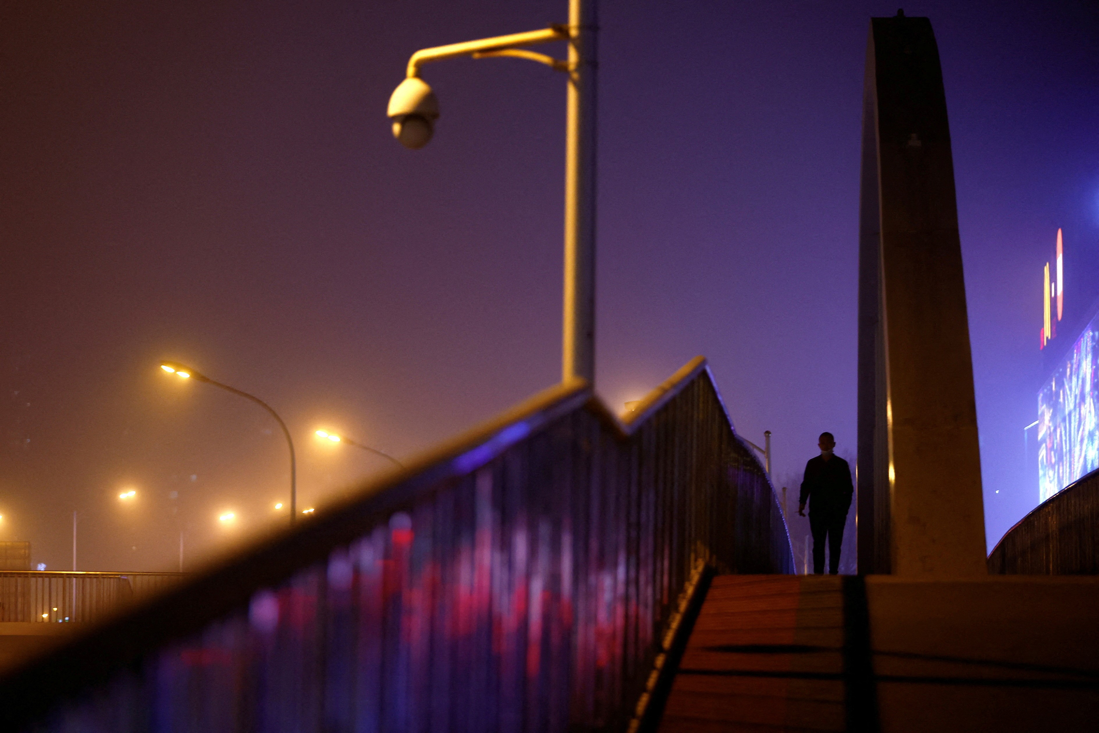 A man walks on an overpass amid a sandstorm as the city is shrouded in smog, in Beijing, China April 10, 2023. Photo: Reuters