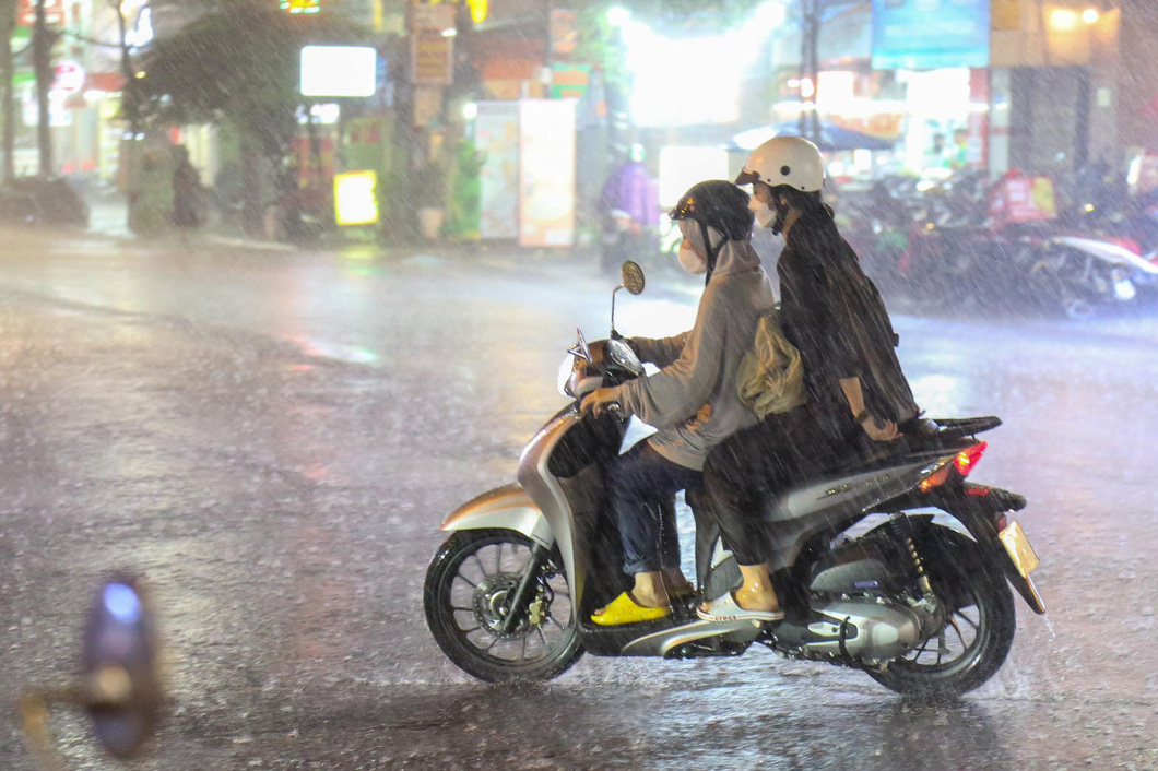 Two girls got drenched in a sudden downpour in Ho Chi Minh City on Saturday evening. Photo: Phuong Quyen / Tuoi Tre