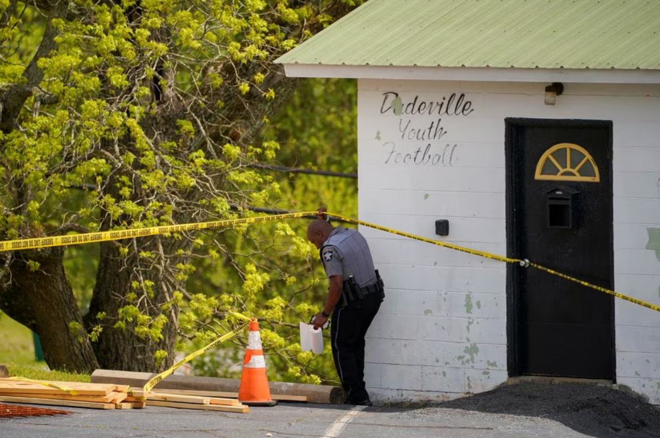 A law enforcement officer goes under a piece of crime scene tape, a day after a shooting at a teenager's birthday party in a dance studio in Dadeville, Alabama, U.S., April 16, 2023. Photo: Reuters