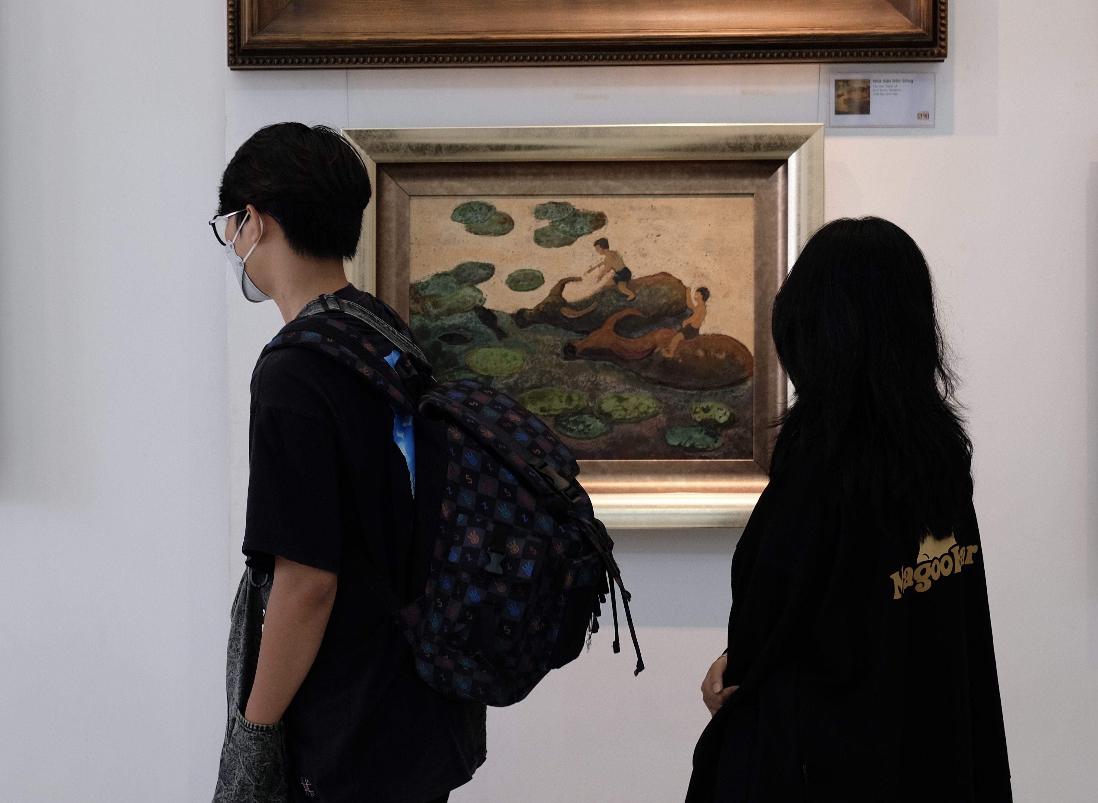 Visitors walk by a painting titled “Mua Len Trau” by Dang Manh Hung at the exhibition. Photo: Phuong Tran / Tuoi Tre News