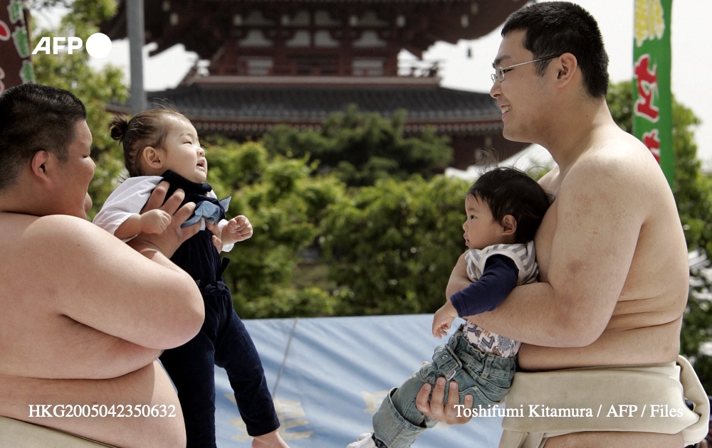Sumo wrestler students attempt to cry out babies during the annual 'crying sumo' competition at the Sensoji temple in central Tokyo, 23 April 2005. Photo: AFP