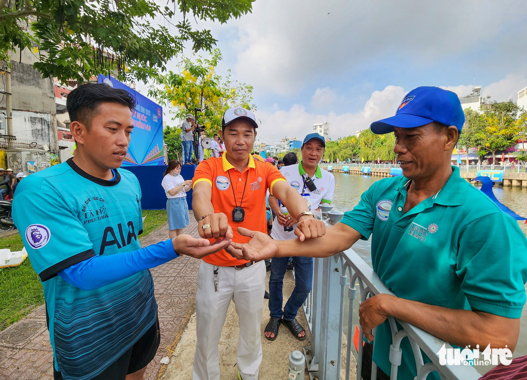 Representatives of two teams draw for their turn in a boat race. Photo: Tuoi Tre