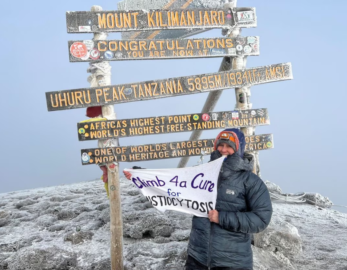 Wendy Nelson stands at Uhuru Peak of Mt. Kilimanjaro, the highest point on the continent of Africa, during a climb to raise funding for cancer research, a bucket list trip she took after a genetic test showed that she carries two copies of the APOE4 gene variant that significantly increases her risk for Alzheimer's disease, in Tanzania, February 17, 2023. Photo: Reuters