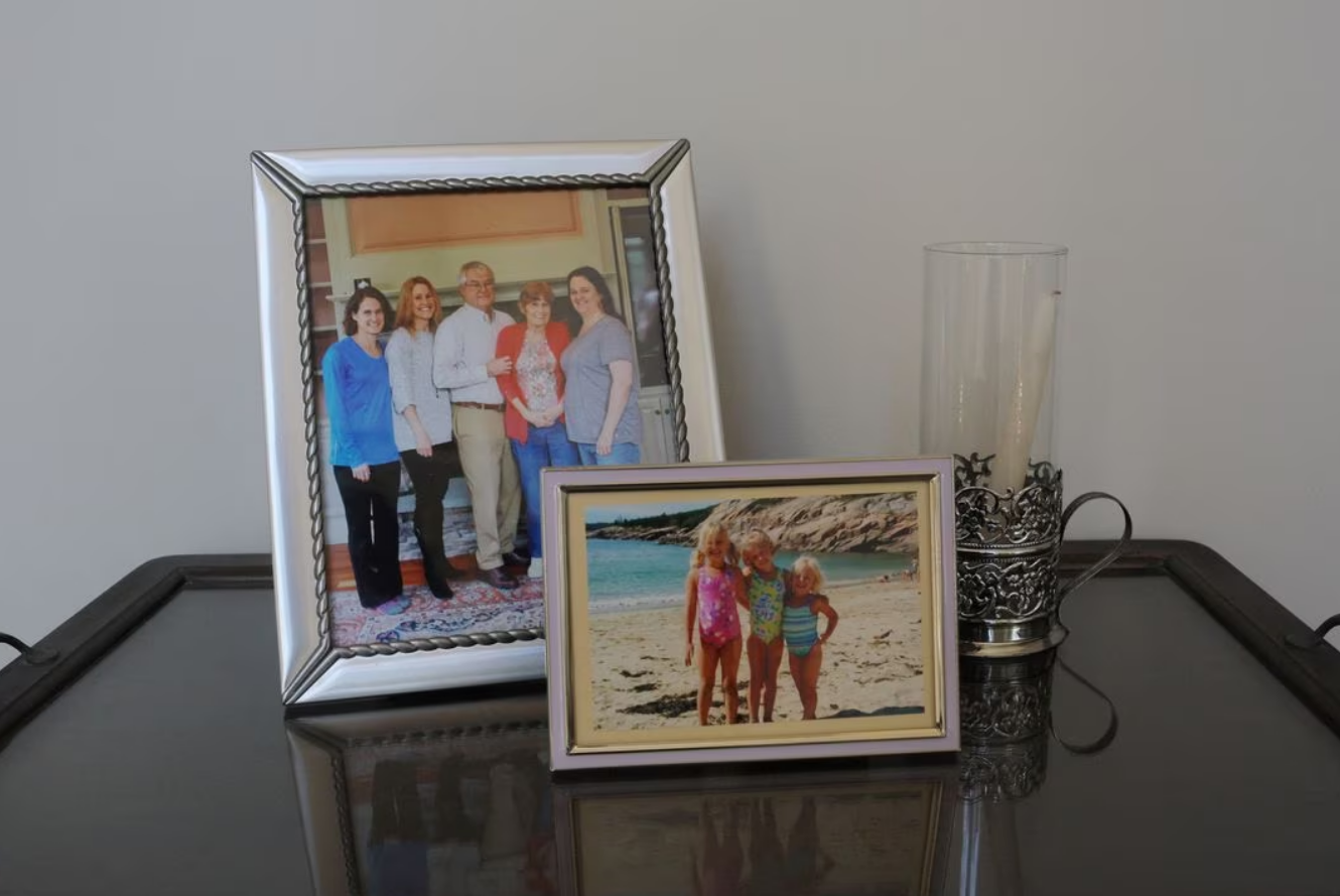 Framed family photographs show Wendy Nelson with her sisters and their parents, as well as her three children, in the foyer of her home in Foxborough, Massachusetts, U.S., March 21, 2023. Wendy Nelson's mother died from Alzheimer's disease, her father suffers from it, and genetic tests show that Wendy carries two APOE4 gene variants, and her three daughters each carry one APOE4 gene variant, indicating an increased risk of Alzheimer's disease. Photo: Reuters