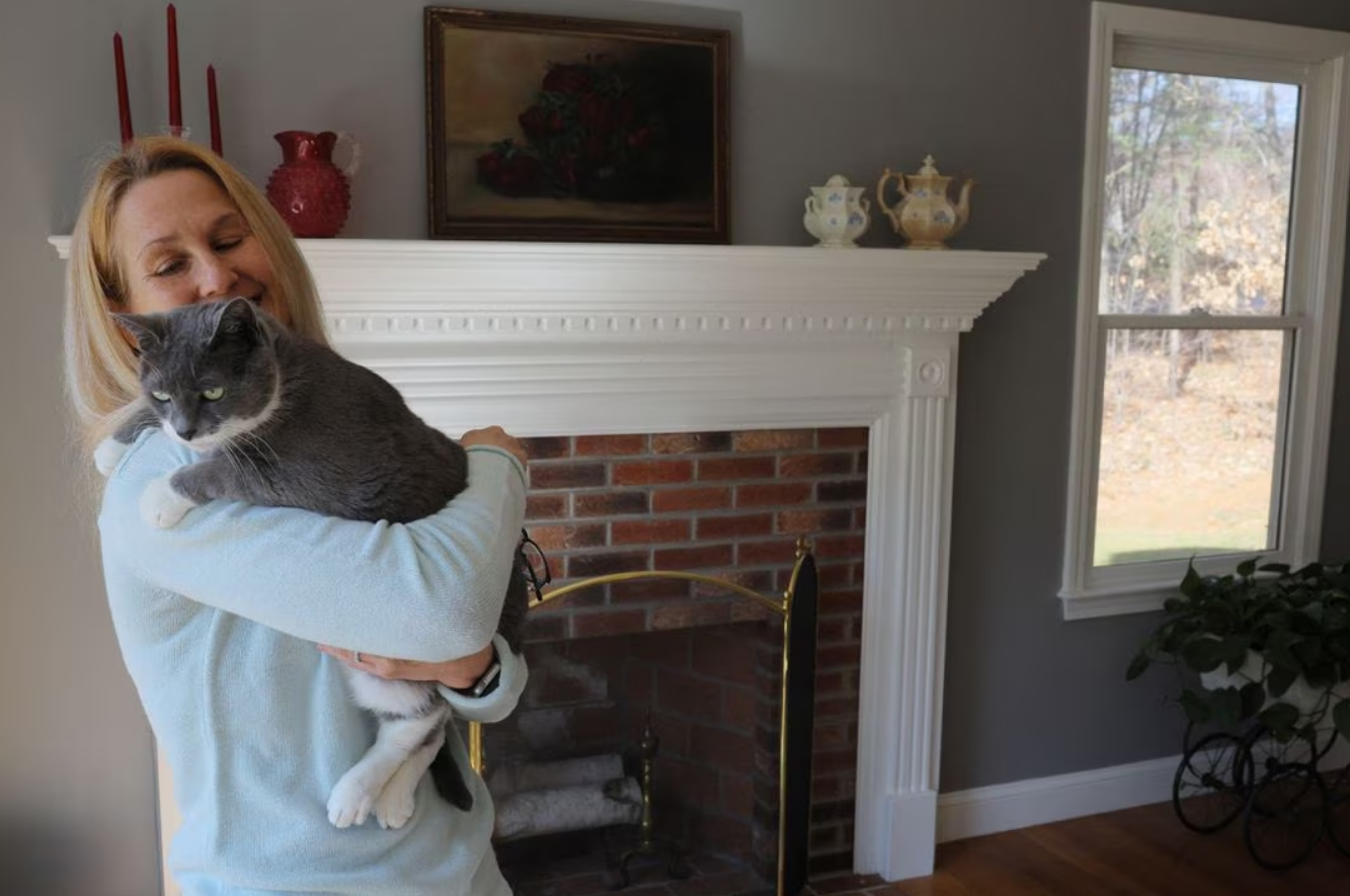 Wendy Nelson holds her cat Piper, in Foxborough, Massachusetts, U.S., March 21, 2023. Nelson's mother died from Alzheimer's disease, her father suffers from it, and genetic tests through 23andMe shows that Wendy carries two APOE4 gene variants, and her three daughters each carry one APOE4 gene variant, indicating an increased risk of Alzheimer's disease. Photo: Reuters