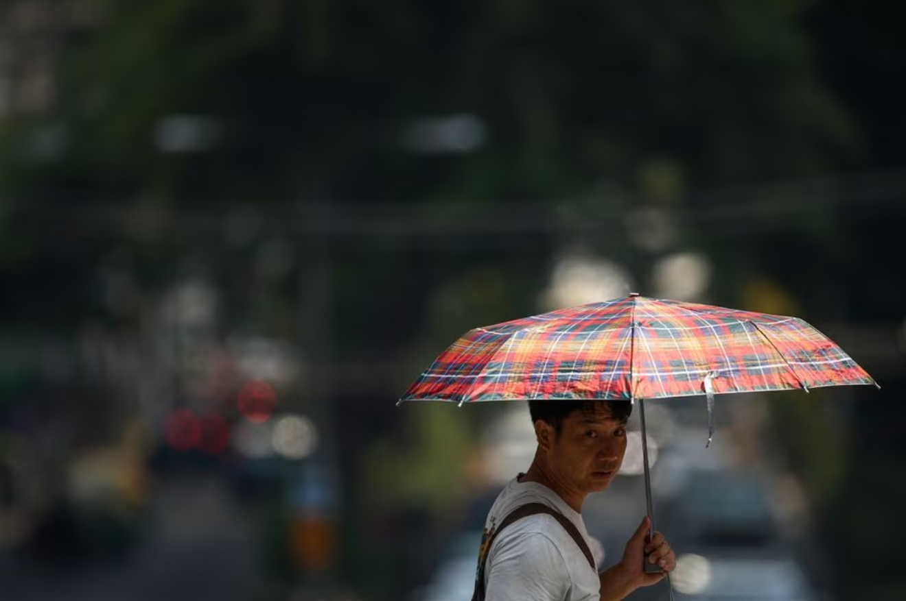 A man holds up an umbrella as temperatures hit a record 45.4 degrees Celsius (113.7 Fahrenheit) in Bangkok, Thailand, April 21, 2023. Photo: Reuters