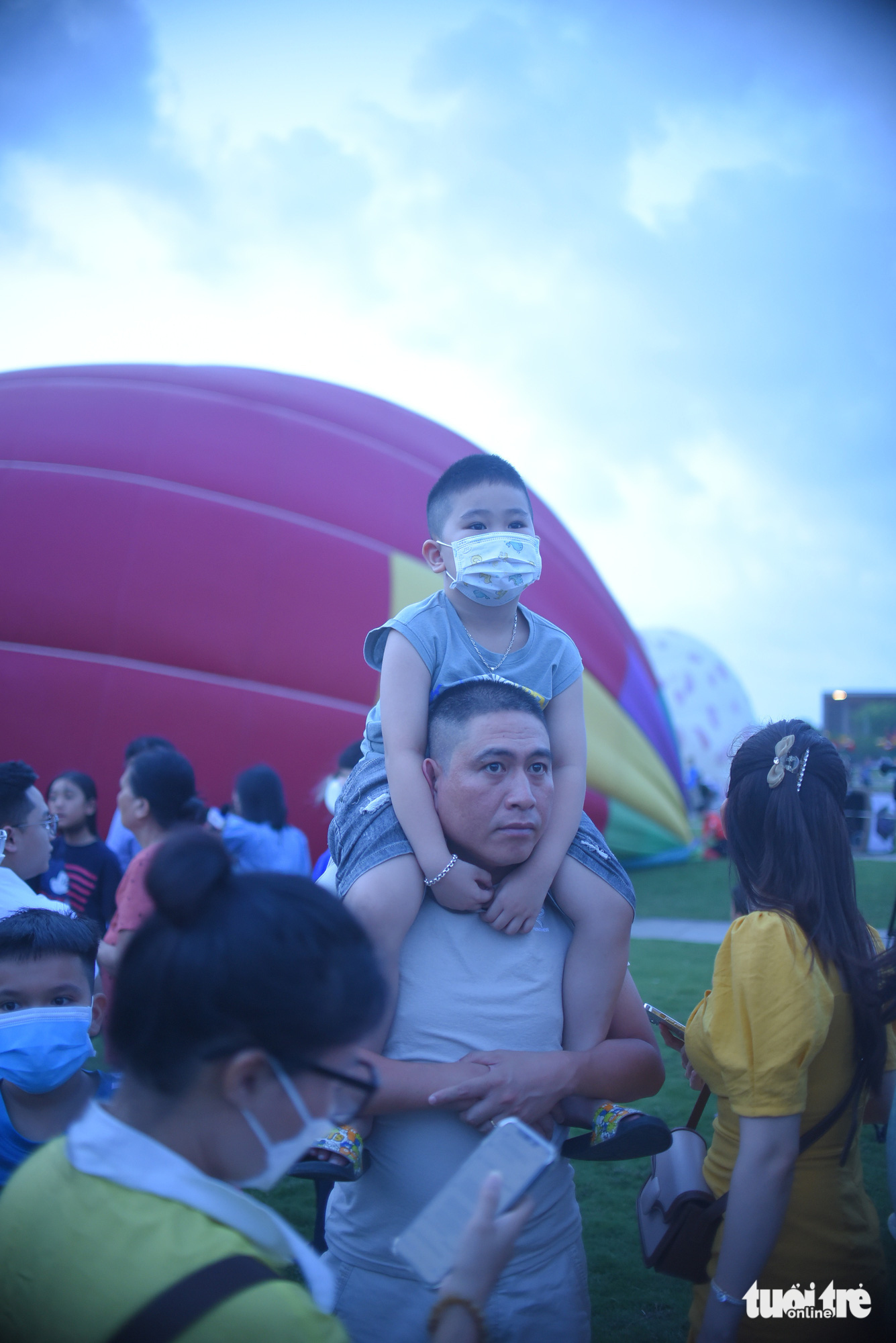 A father carrying his kid on the shoulder watches a hot-air balloon show in Quy Nhon City, Binh Dinh Province, south-central Vietnam, April 25, 2023. Photo: Lam Thien / Tuoi Tre