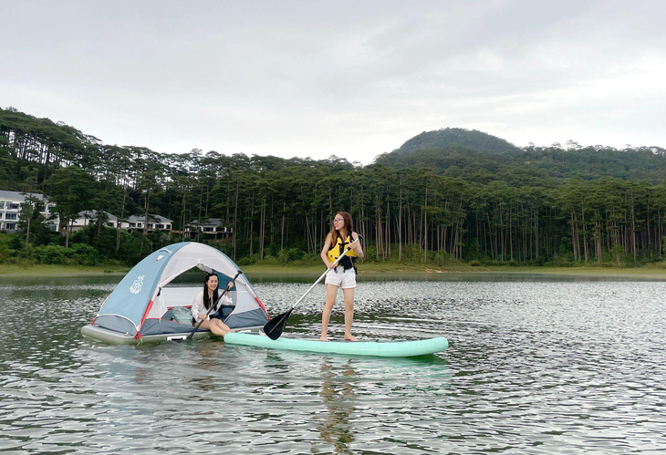 Two women go SUPing in Tuyen Lam Lake, Da Lat City, Lam Dong Province. Photo: M.V. / Tuoi Tre