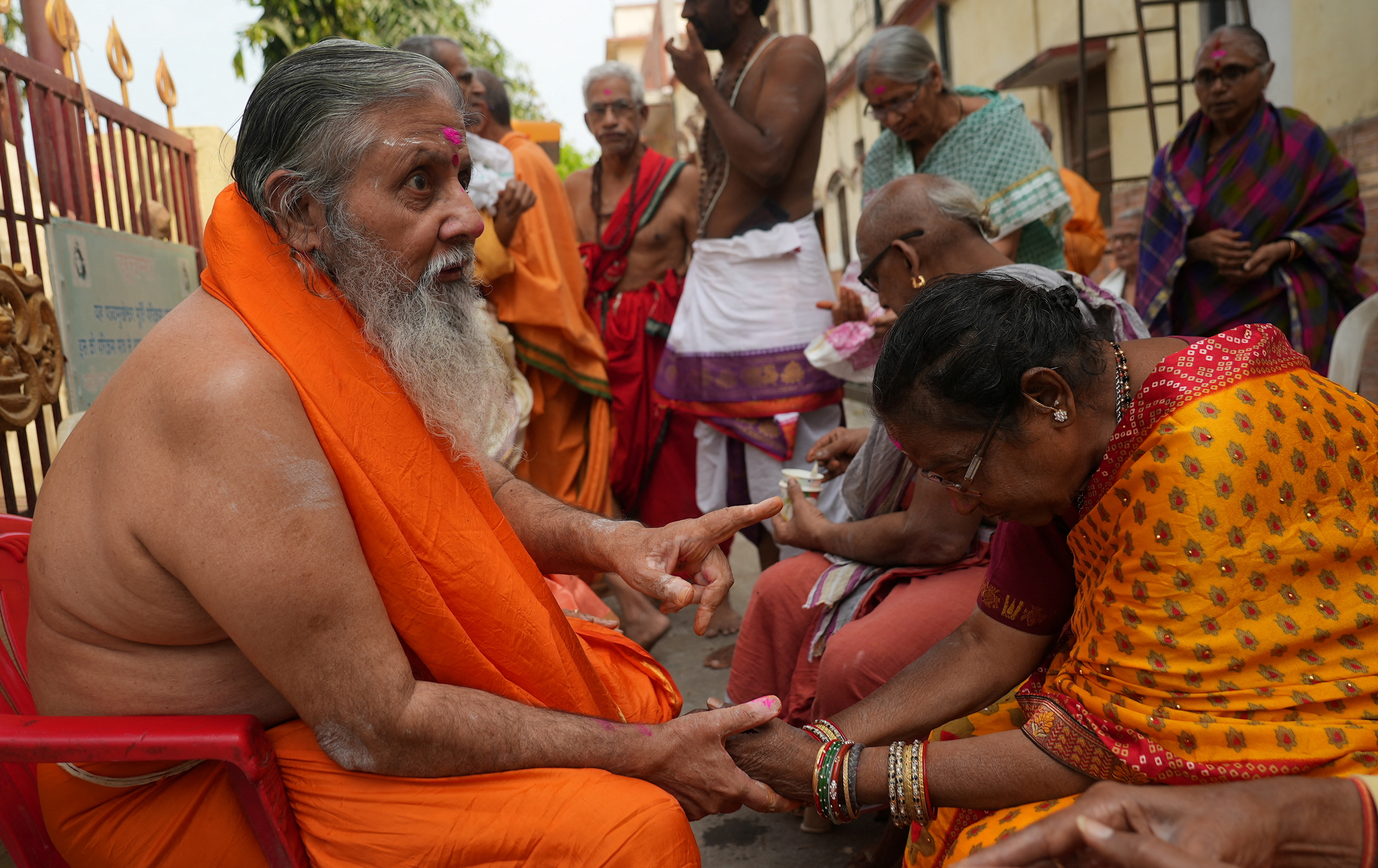 A resident of Mumukshu Bhavan, a community home for elderly wishing to live and end their twilight years in the sacred city of Varanasi, asks for release from physical pain from a holy man in Varanasi, India, March 7, 2023. Photo: Reuters