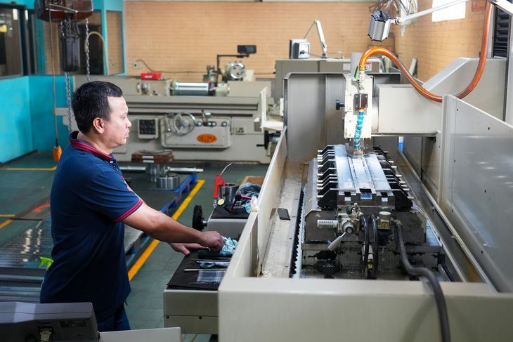 An employee at work in a production facility. Photo: Huu Hanh / Tuoi Tre