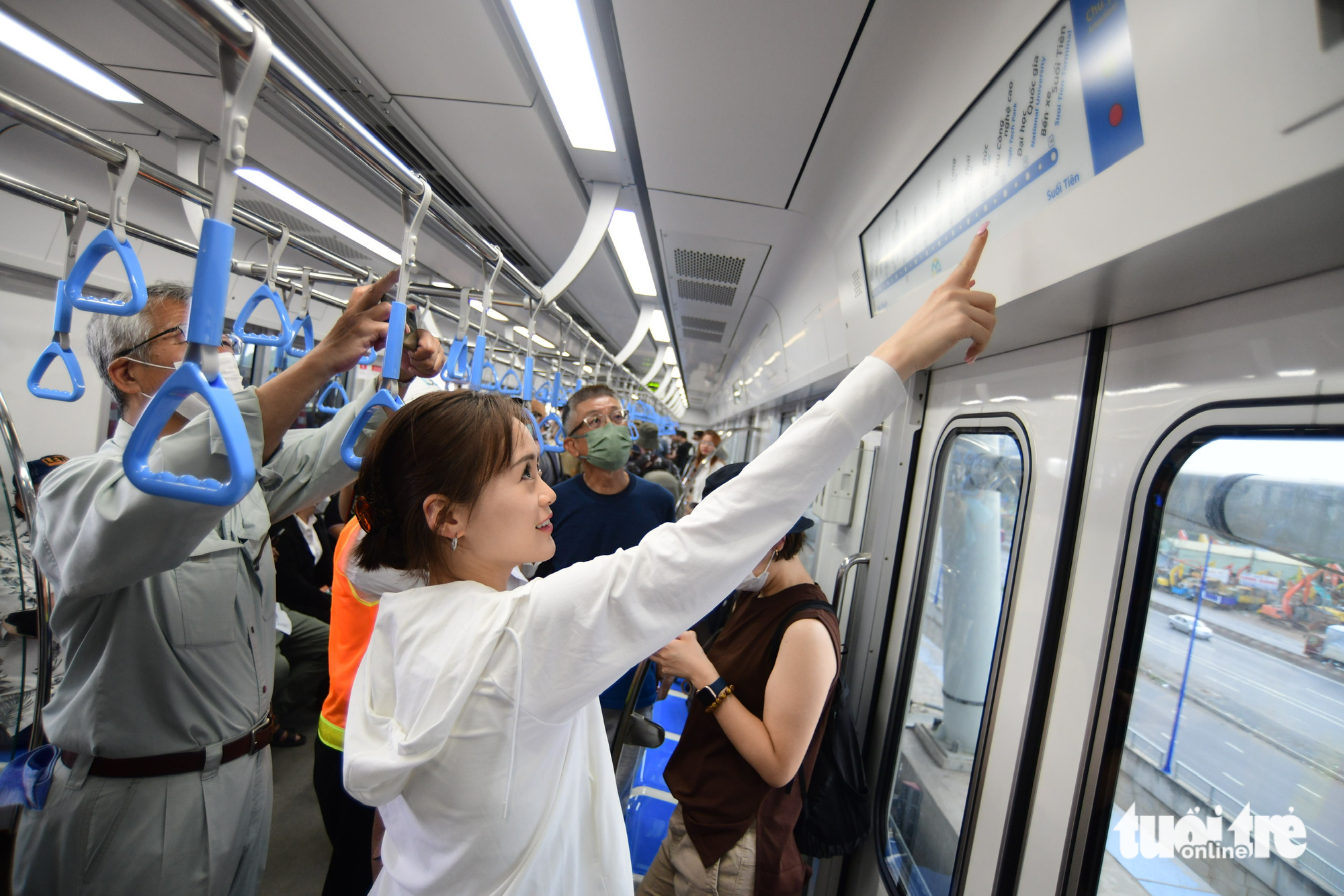 Passengers watch a list of stations near the entrance of the metro train. Photo: Quang Dinh / Tuoi Tre
